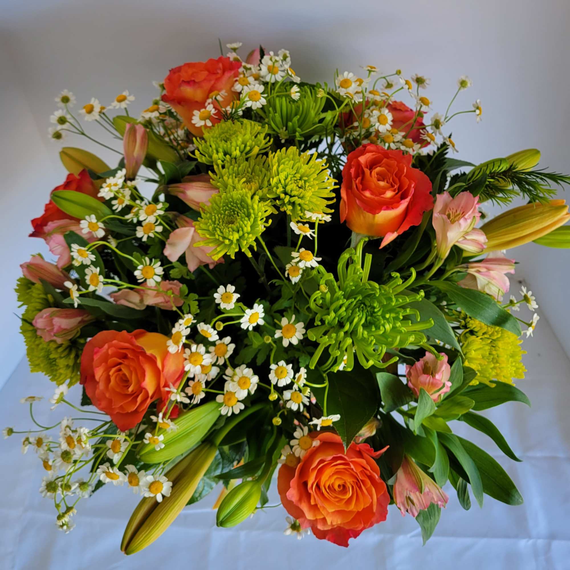 Gorgeous gathering of roses, lilies, alstroemeria, poms, waxflower, monte casino and salal