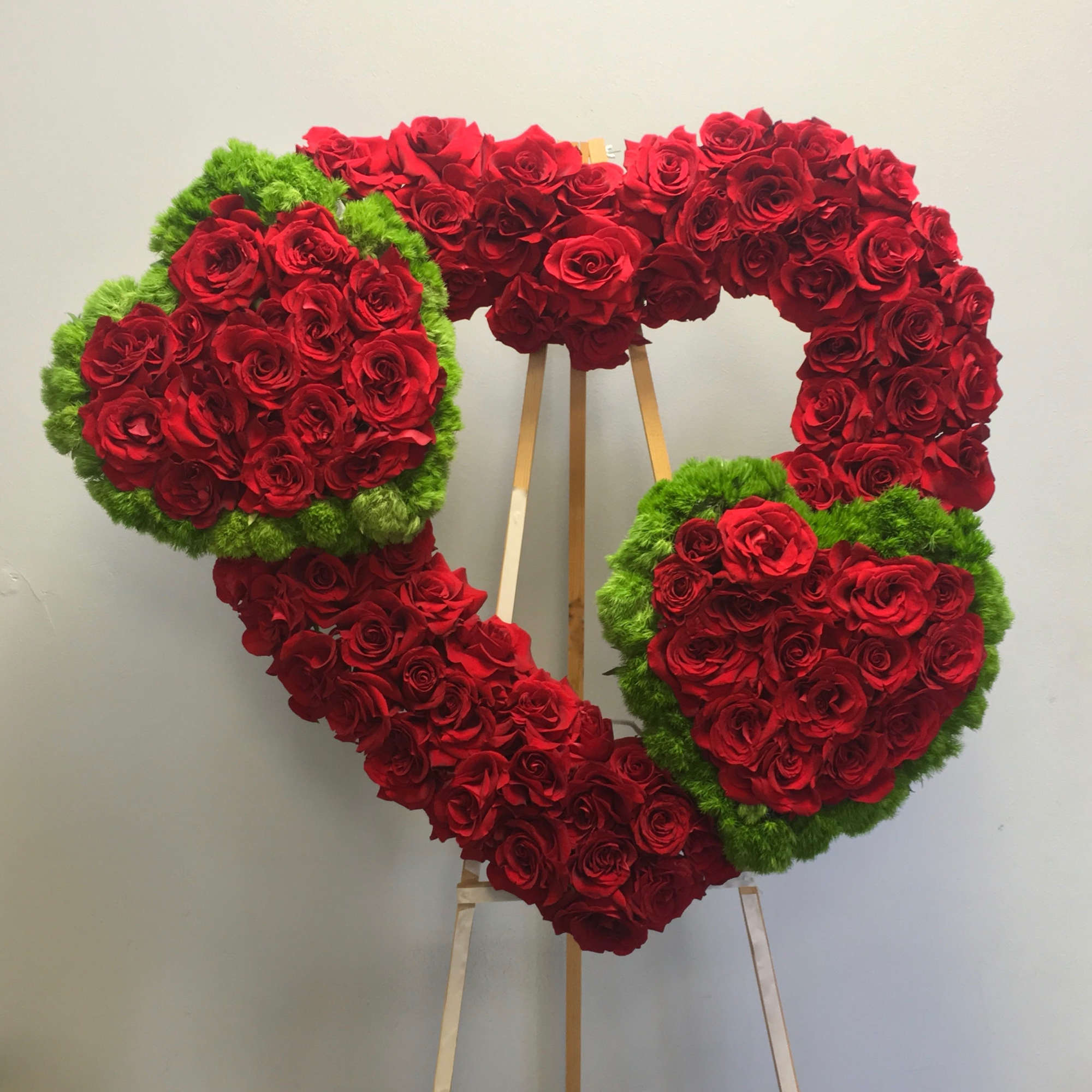 Three hearts in one, all containing red roses. The two smaller hearts