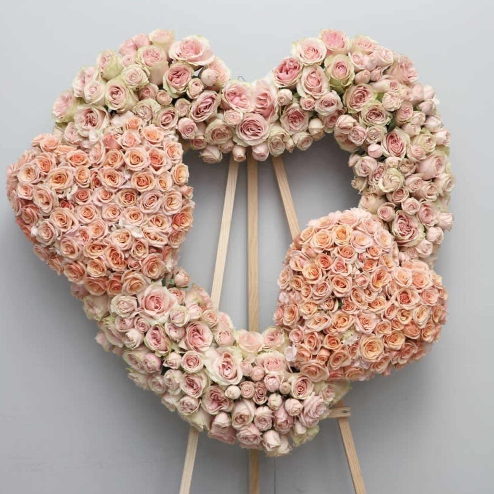 Three hearts in one, all containing red roses. The two smaller hearts