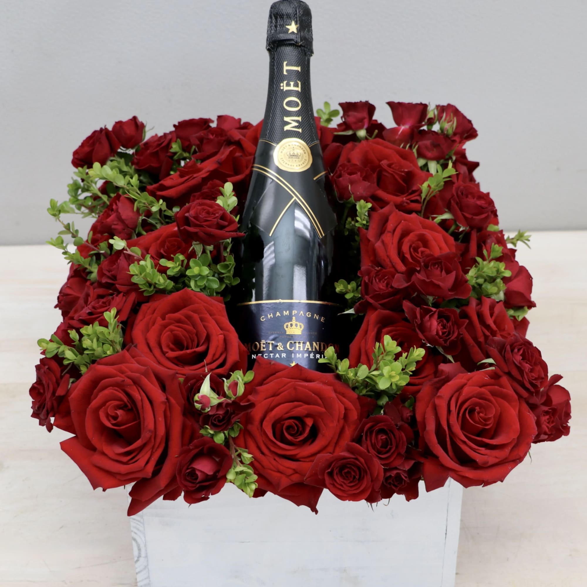 Feature your favorite bottle of bubbly surrounded lush red roses. Perfect for