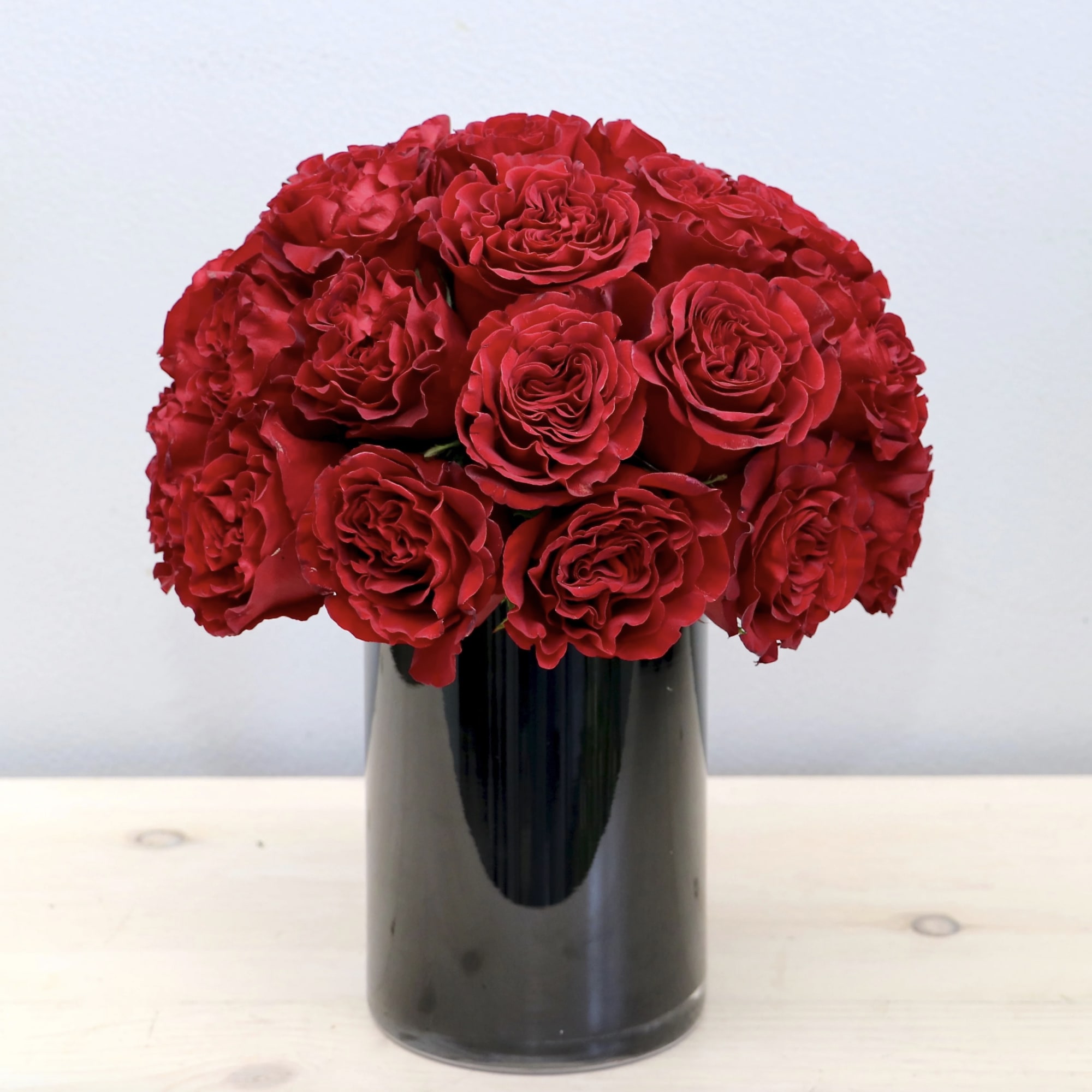 Red garden roses are the highlight of this arrangement, making it the