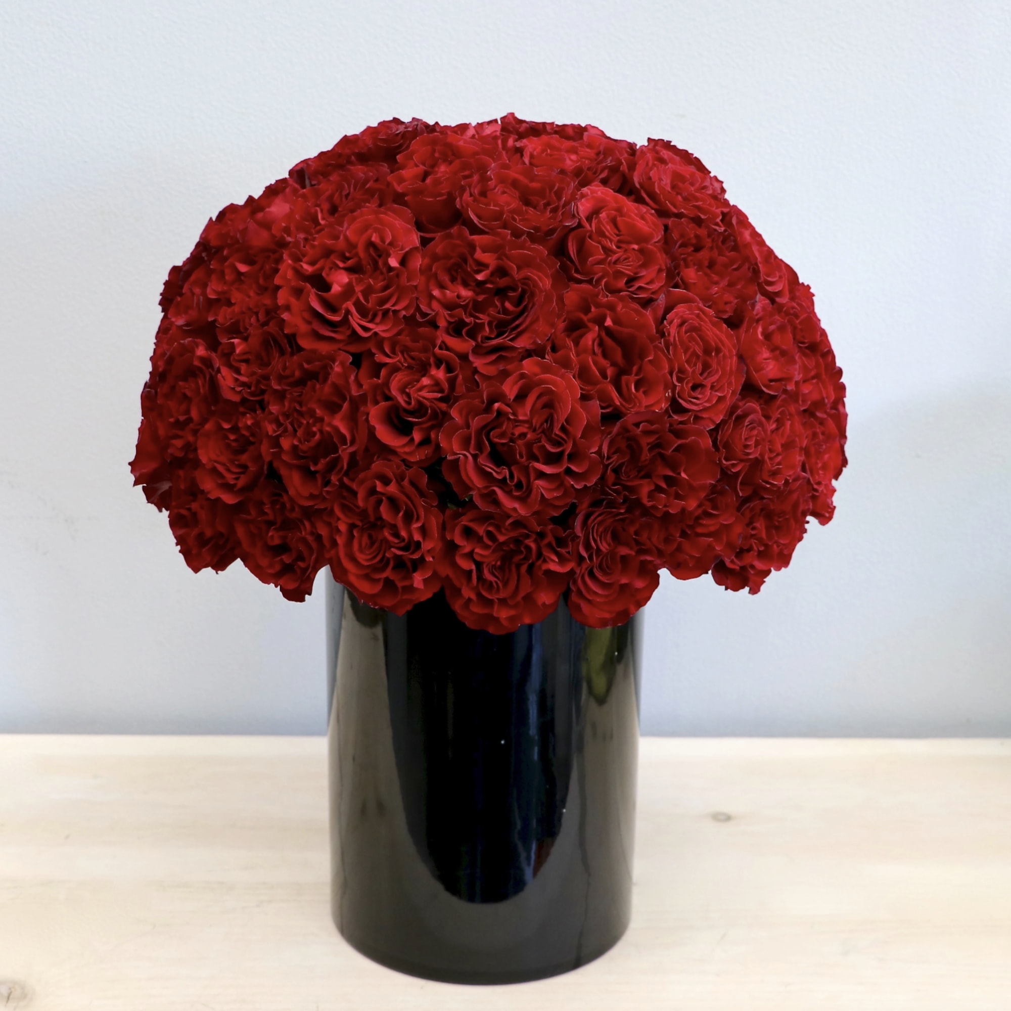 Red garden roses are the highlight of this arrangement, making it the