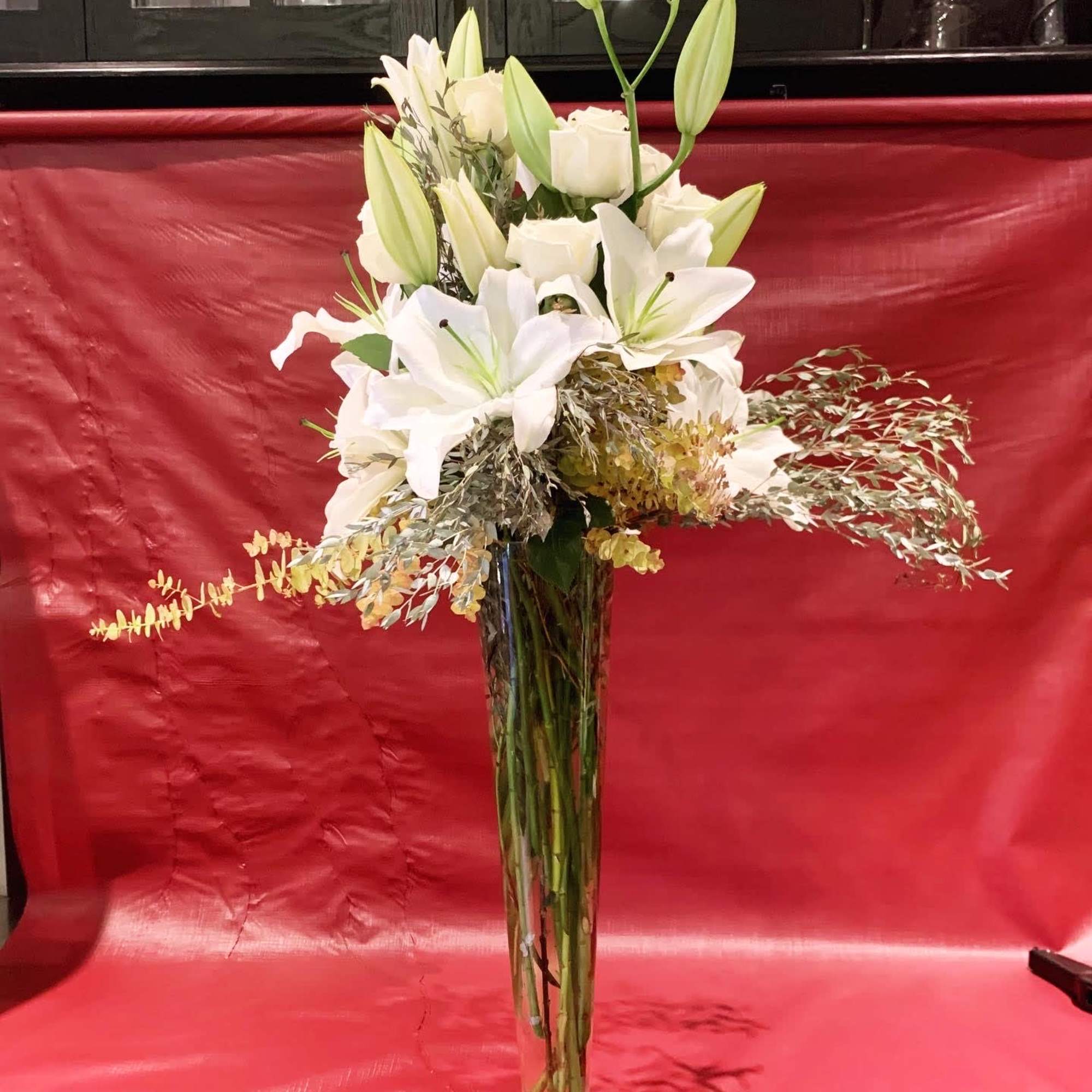 Custom arrangement of Casablanca lilies, white roses & eucalyptus in clear glass Custom arrangement of Casablanca lilies, white roses & eucalyptus in clear glass