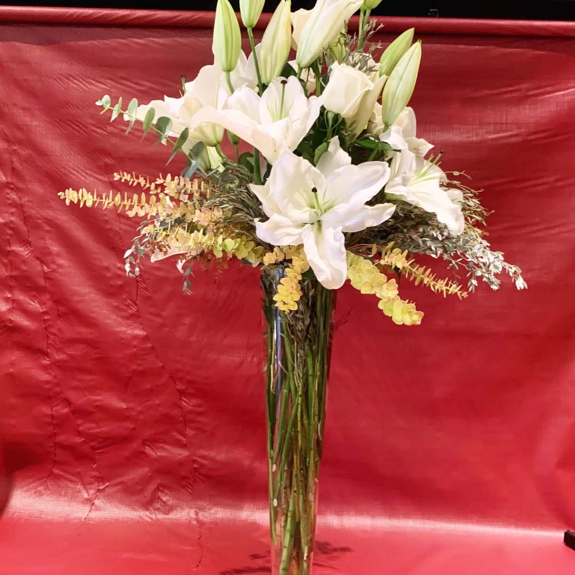 Custom arrangement of Casablanca lilies, white roses & eucalyptus in clear glass Custom arrangement of Casablanca lilies, white roses & eucalyptus in clear glass