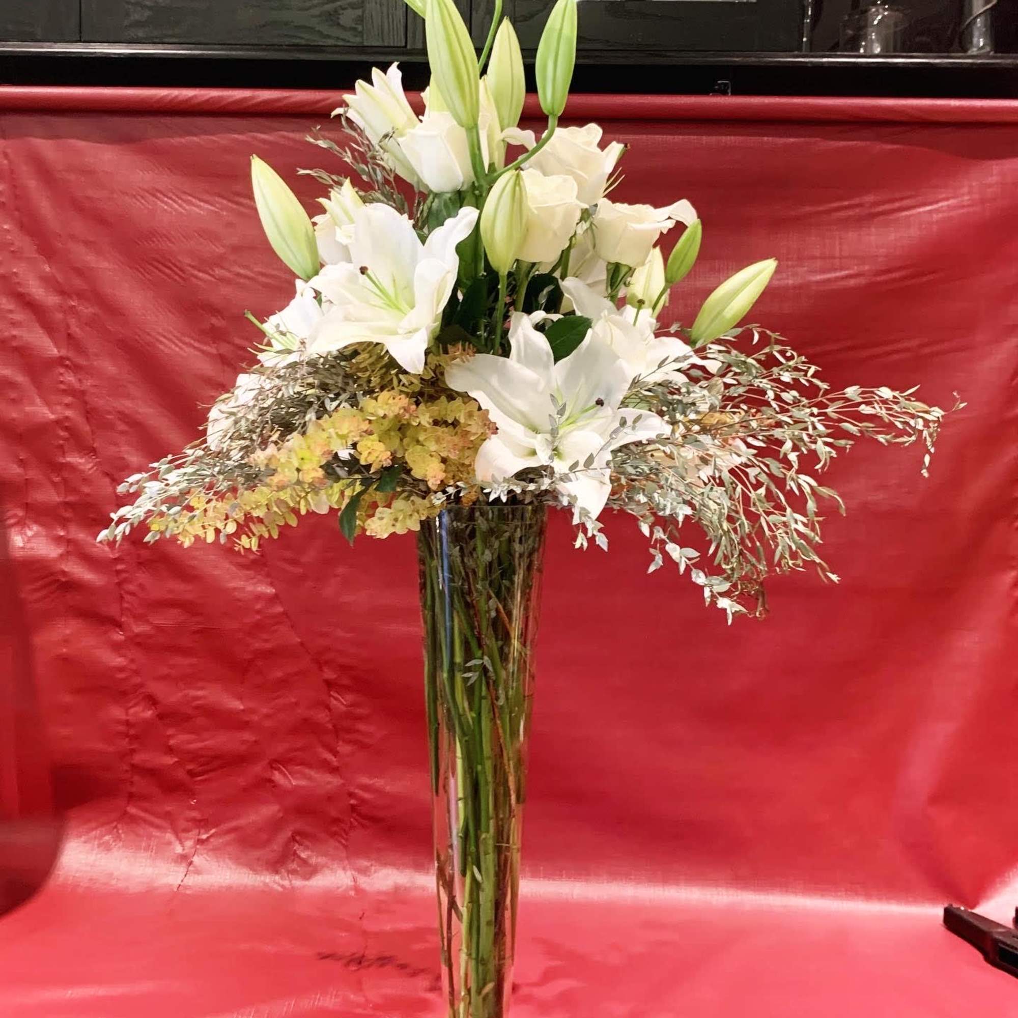 Custom arrangement of Casablanca lilies, white roses & eucalyptus in clear glass Custom arrangement of Casablanca lilies, white roses & eucalyptus in clear glass