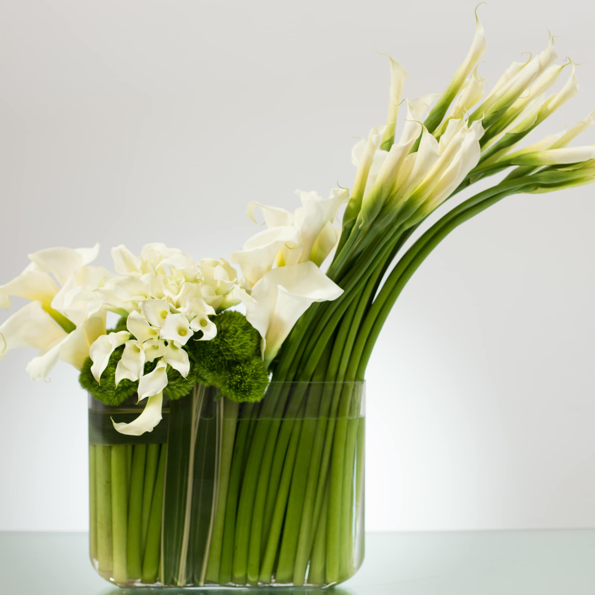 A large arrangement with a beautifully sculptured swoop of Calla Lillies and