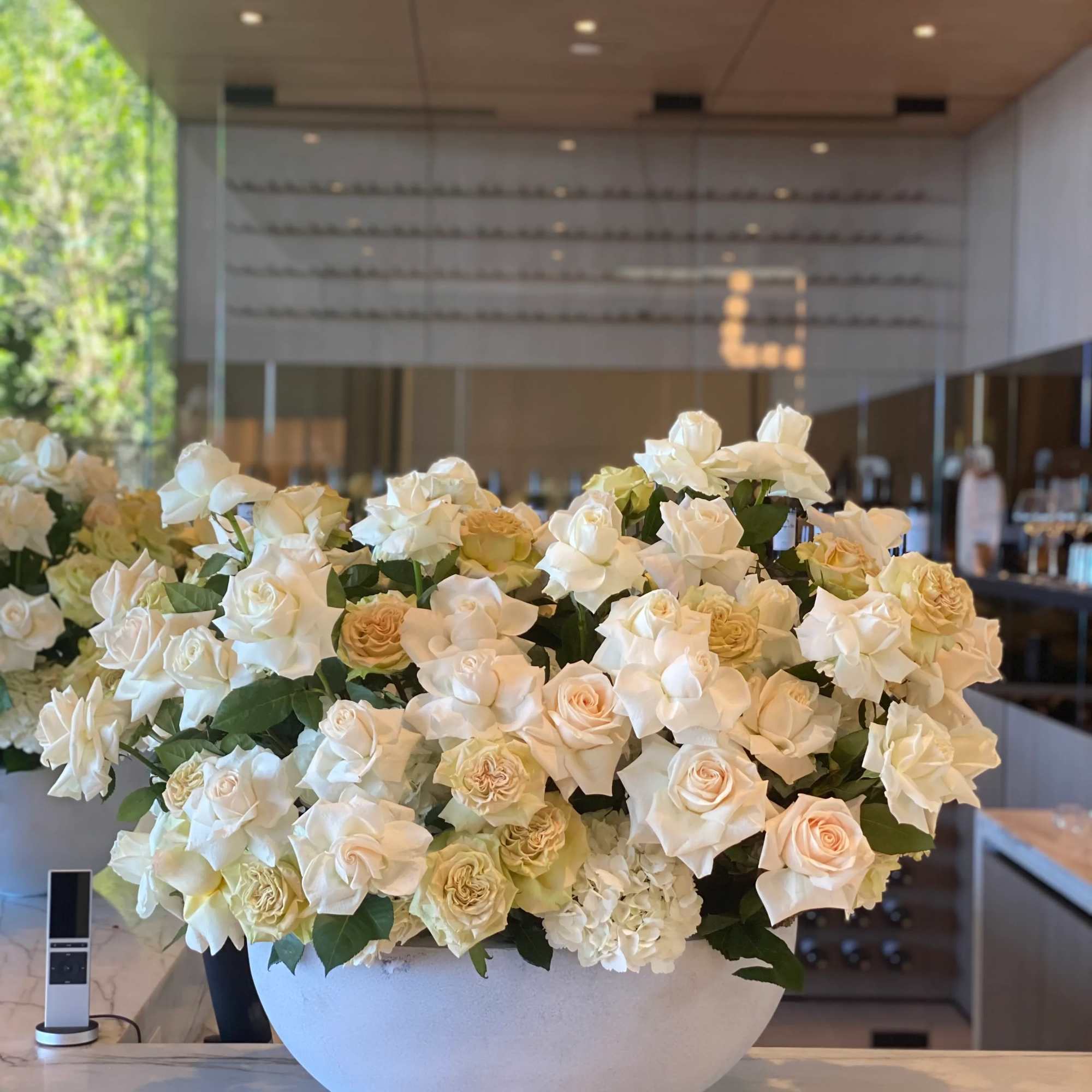 White and beige roses beautifully arranged in a gray vase, offering a