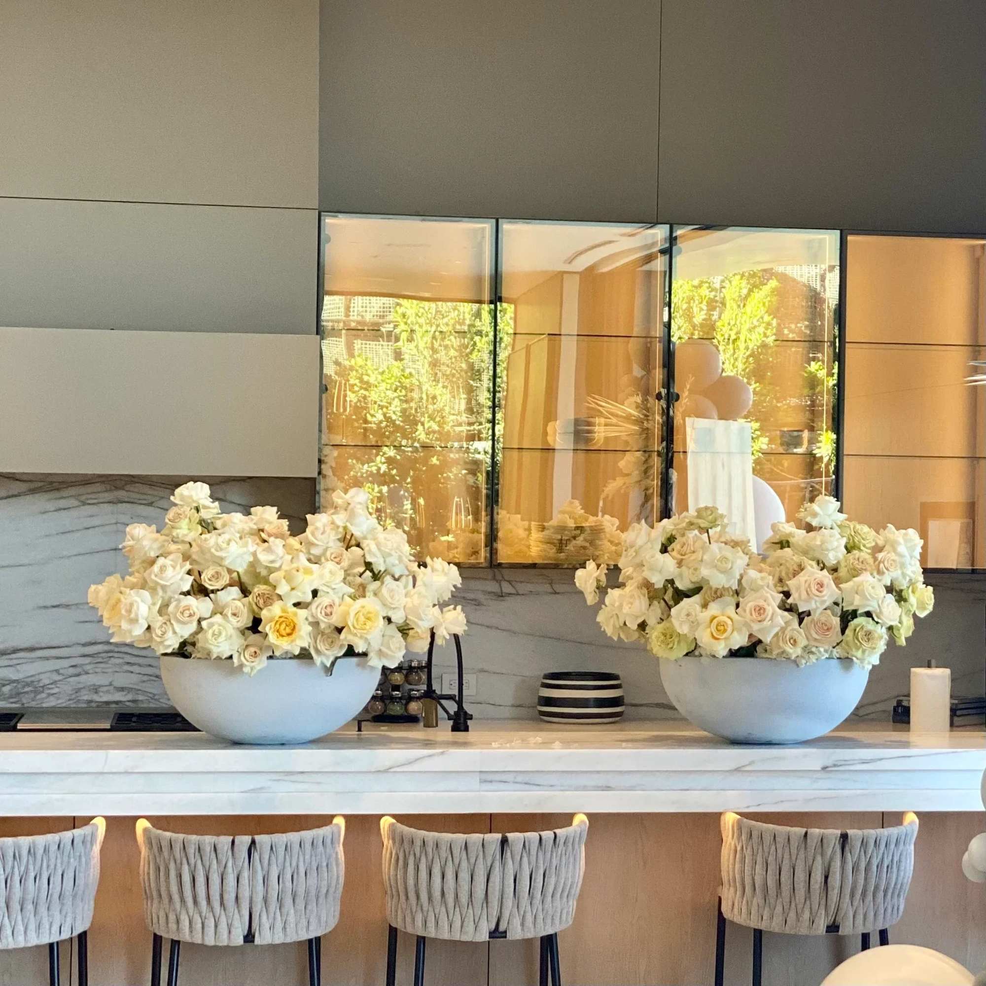 White and beige roses beautifully arranged in a gray vase, offering a