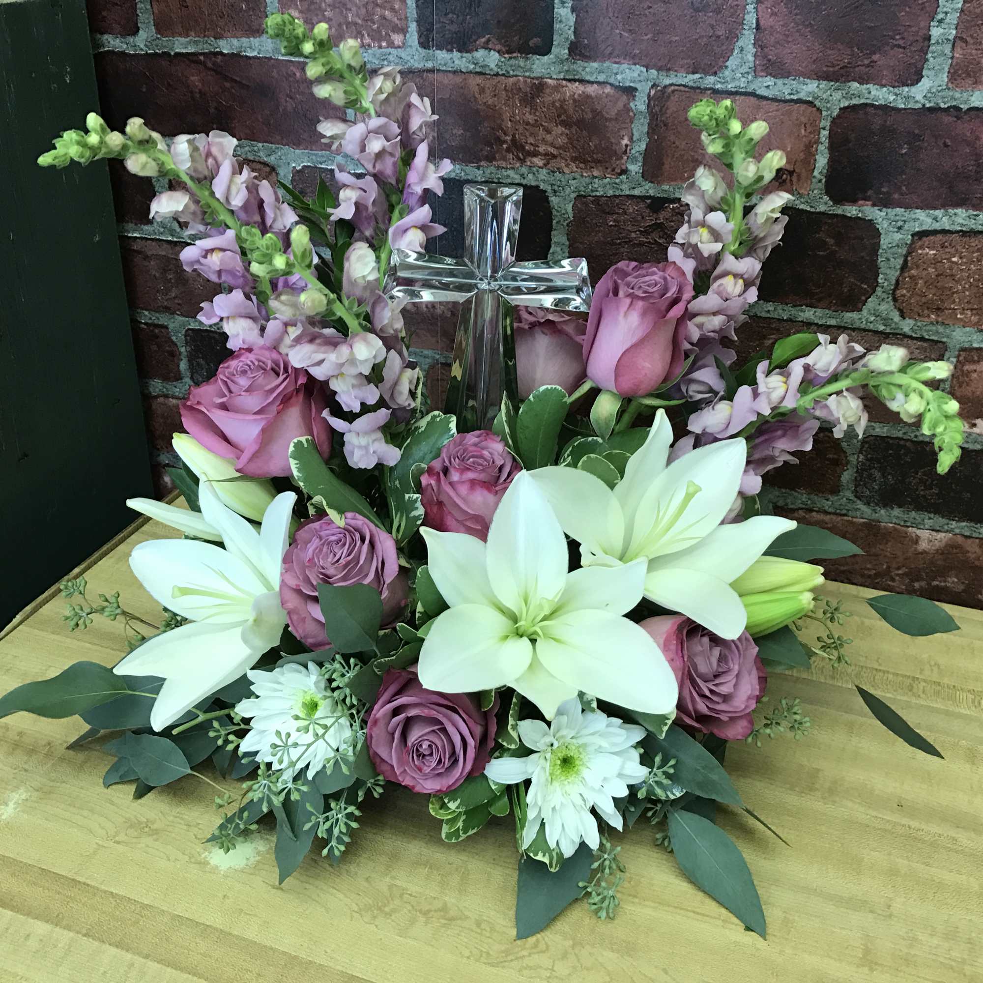 The beautiful crystal cross is surrounded by a multitude of gorgeous blooms. The beautiful crystal cross is surrounded by a multitude of gorgeous blooms.