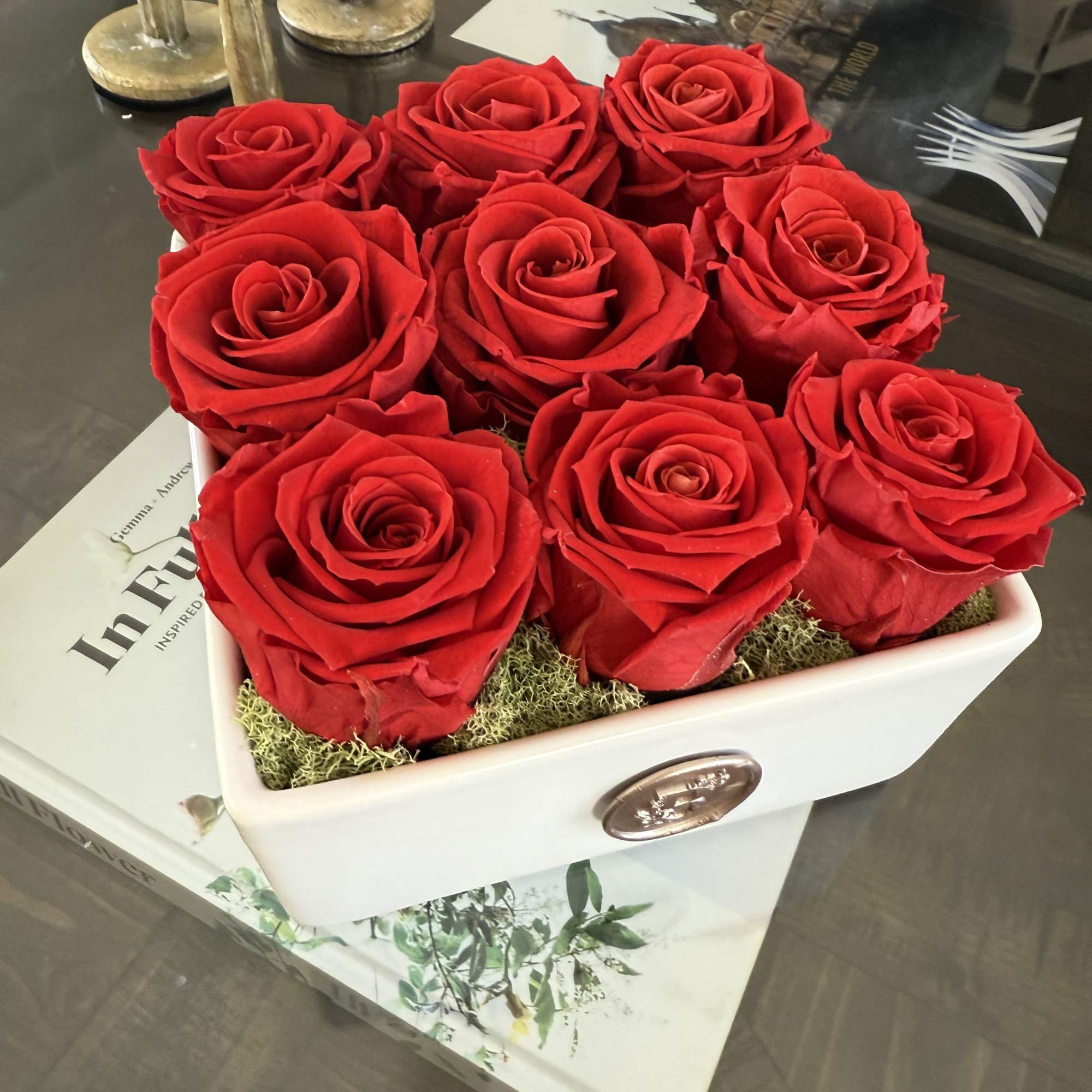 This elegant arrangement features nine vibrant, preserved red roses, artfully arranged in This elegant arrangement features nine vibrant, preserved red roses, artfully arranged in