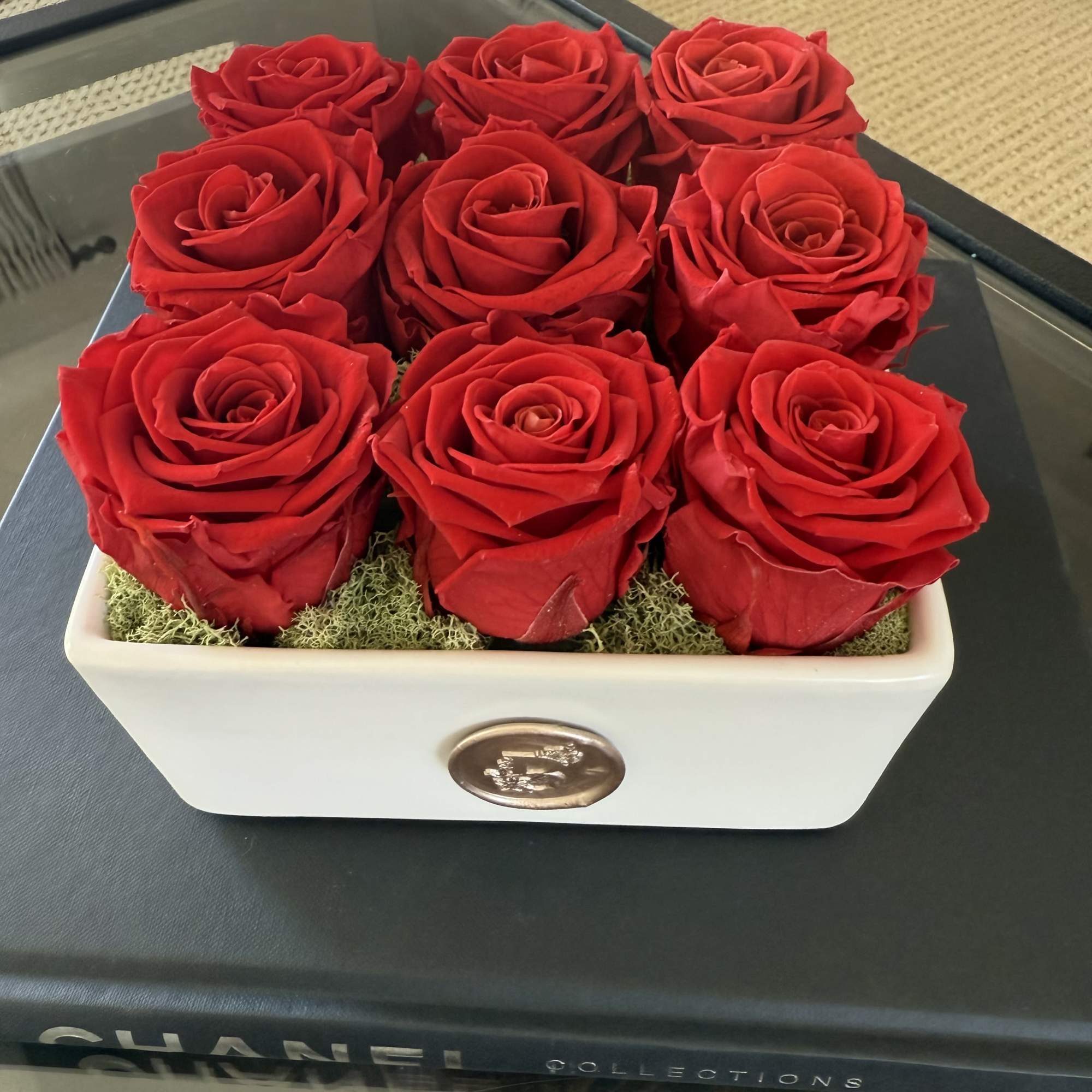 This elegant arrangement features nine vibrant, preserved red roses, artfully arranged in This elegant arrangement features nine vibrant, preserved red roses, artfully arranged in