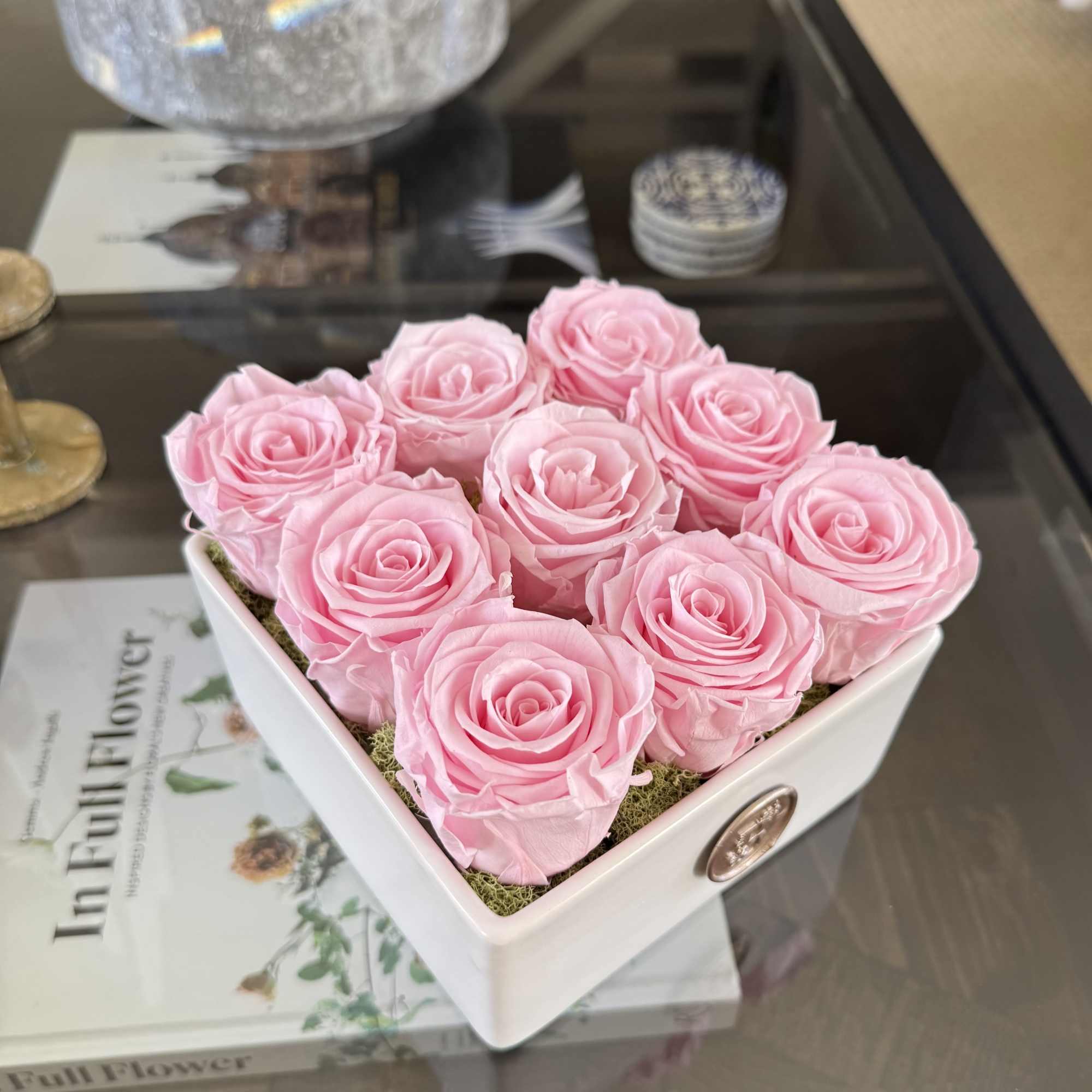 This elegant arrangement features nine preserved pink roses, artfully arranged in a This elegant arrangement features nine preserved pink roses, artfully arranged in a