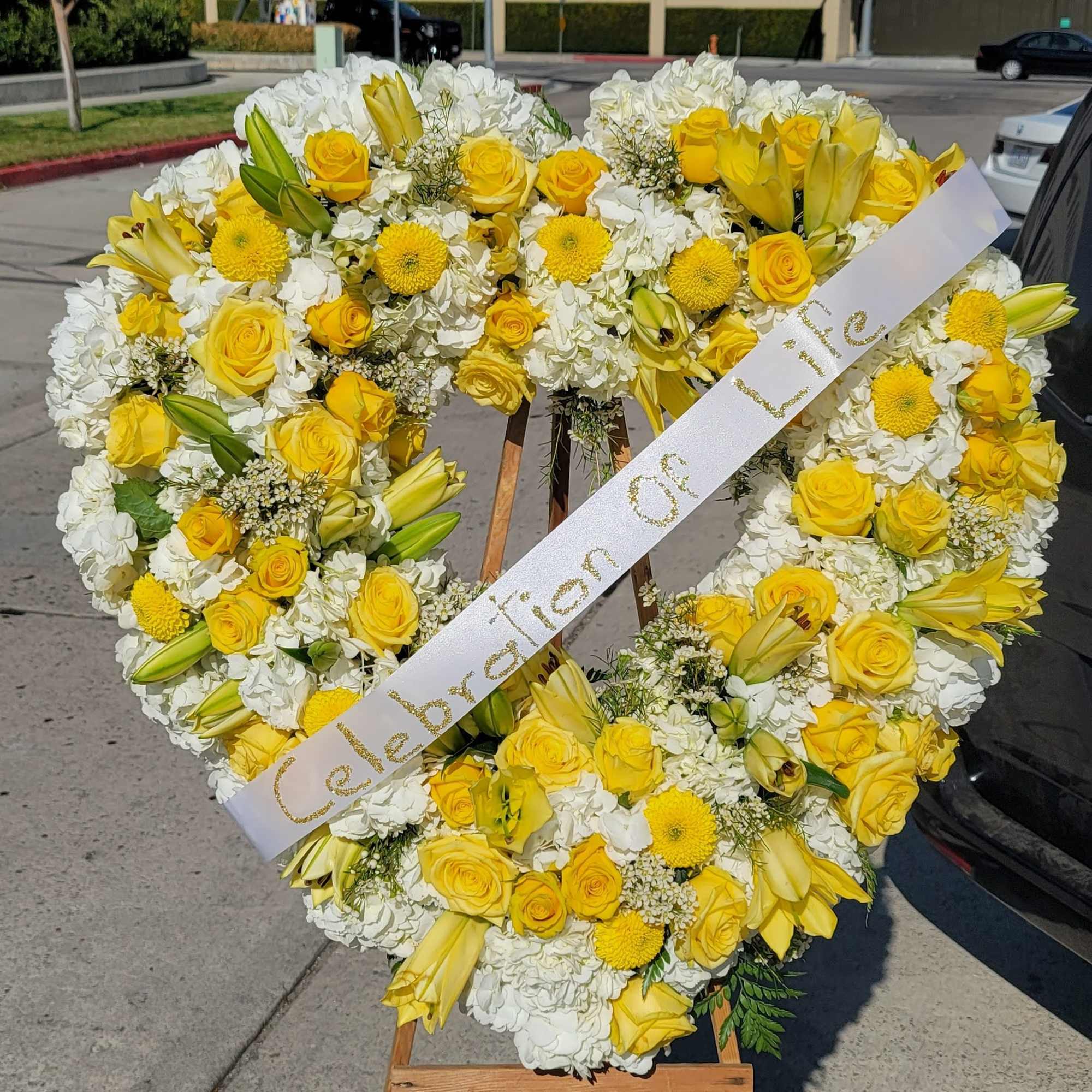 An Opened or Enclosed Heart Floral spray. 
Custom-printed ribbons are available. Please