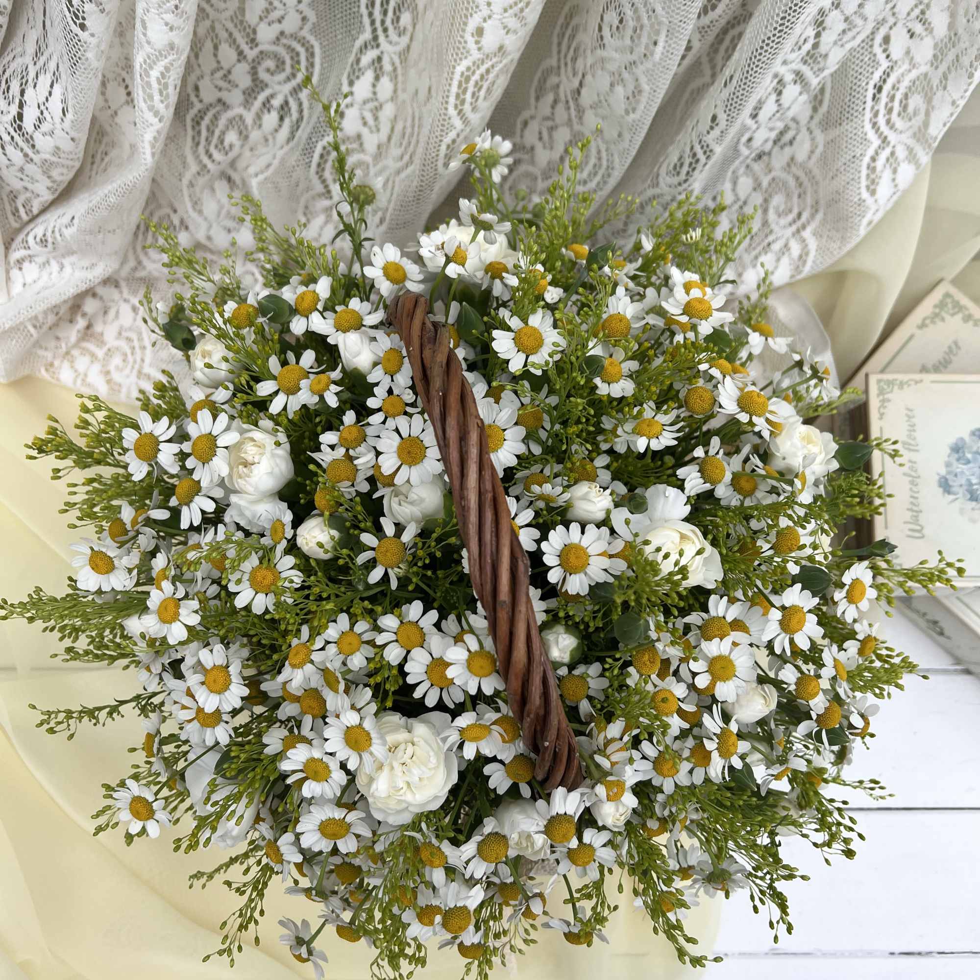 This charming basket arrangement features an abundance of pure daisies, symbolizing innocence