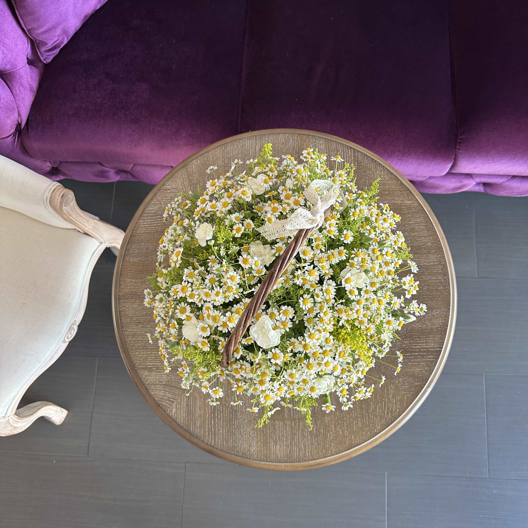 This charming basket arrangement features an abundance of pure daisies, symbolizing innocence