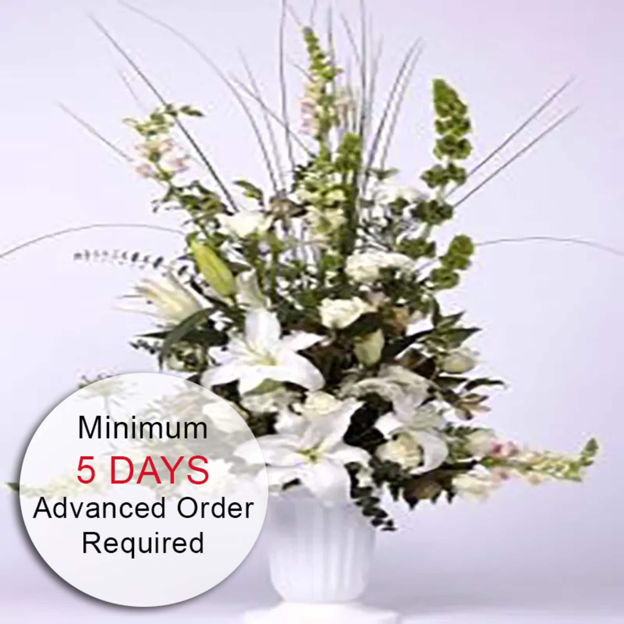 An elegant floral arrangement featuring stunning white lilies harmonized with lush green