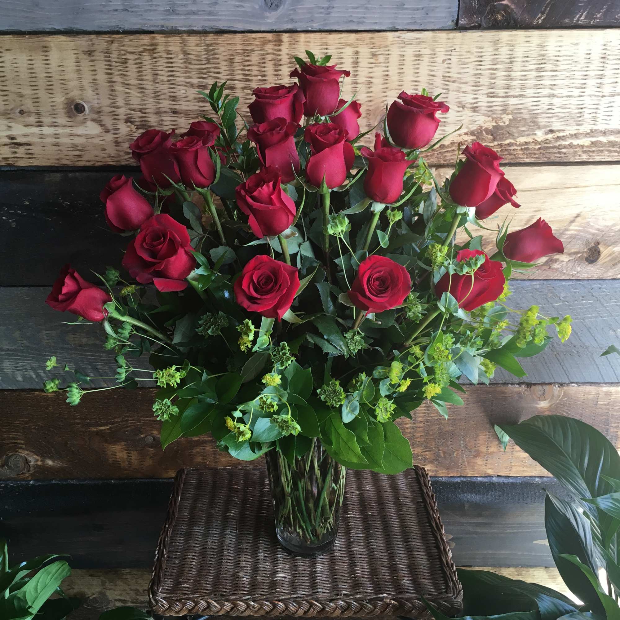 Two dozen deep red roses arranged with premium greens.