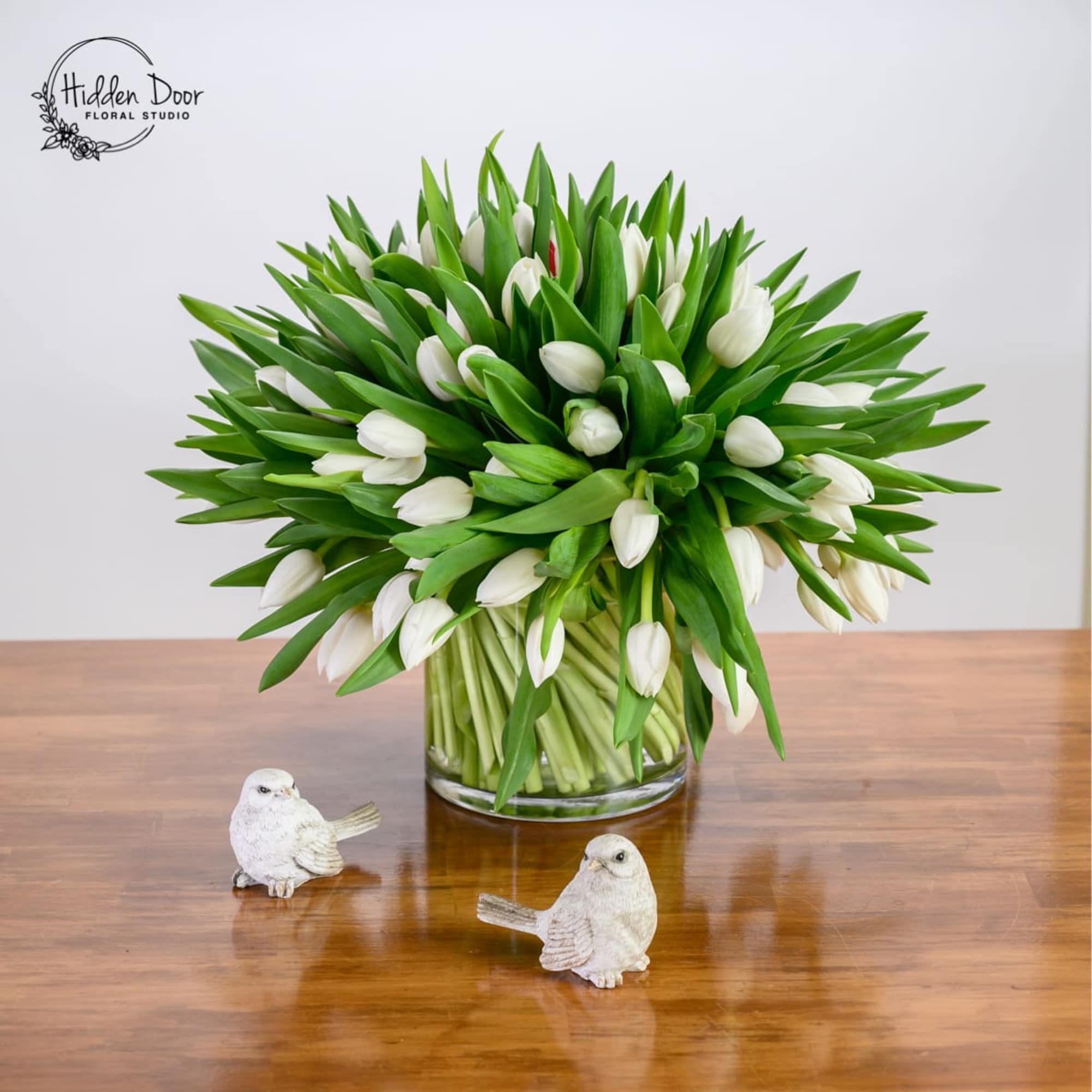 A large white arrangement made entirely from 100 tulips. 