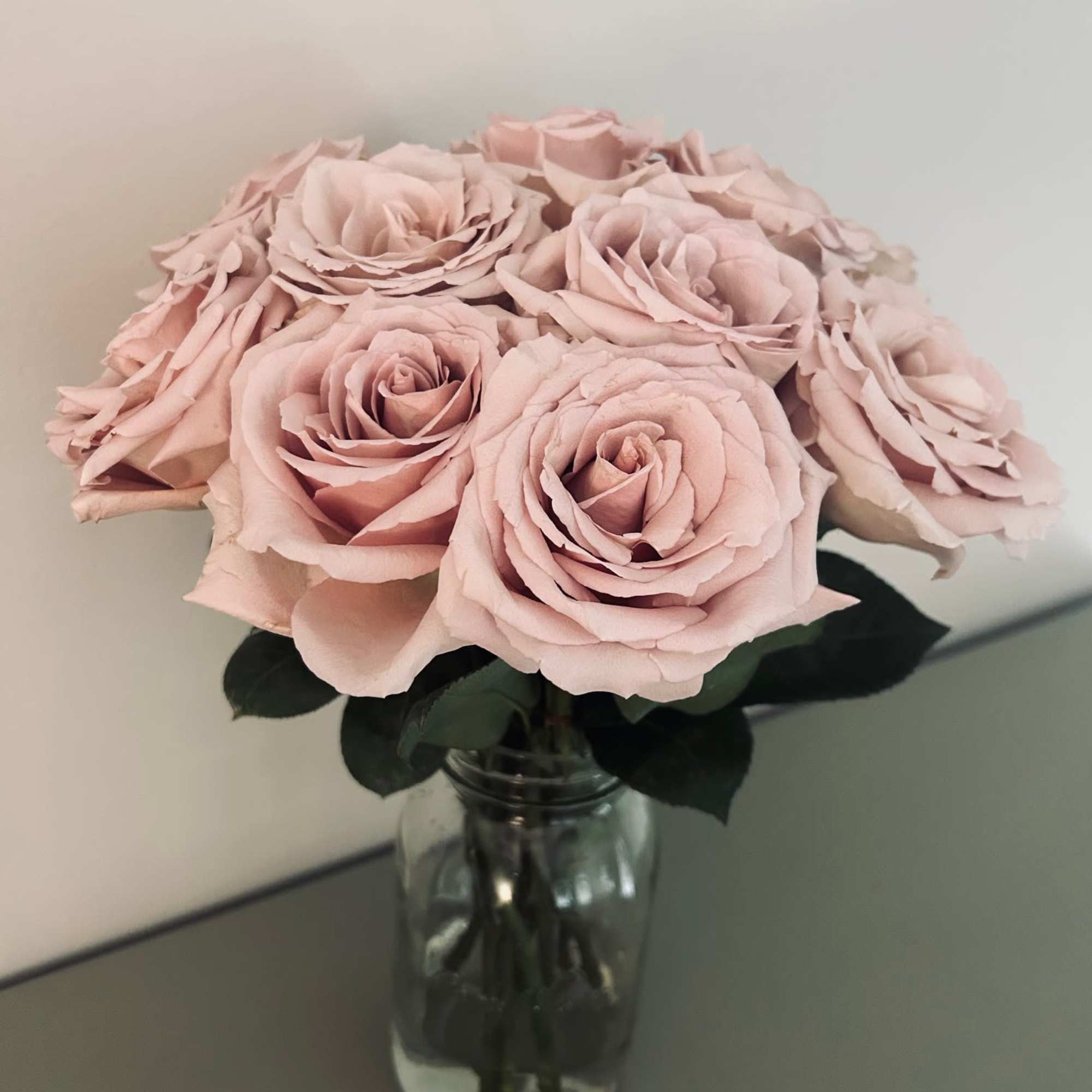 12 fresh cut roses of your color choice arranged delicately in a