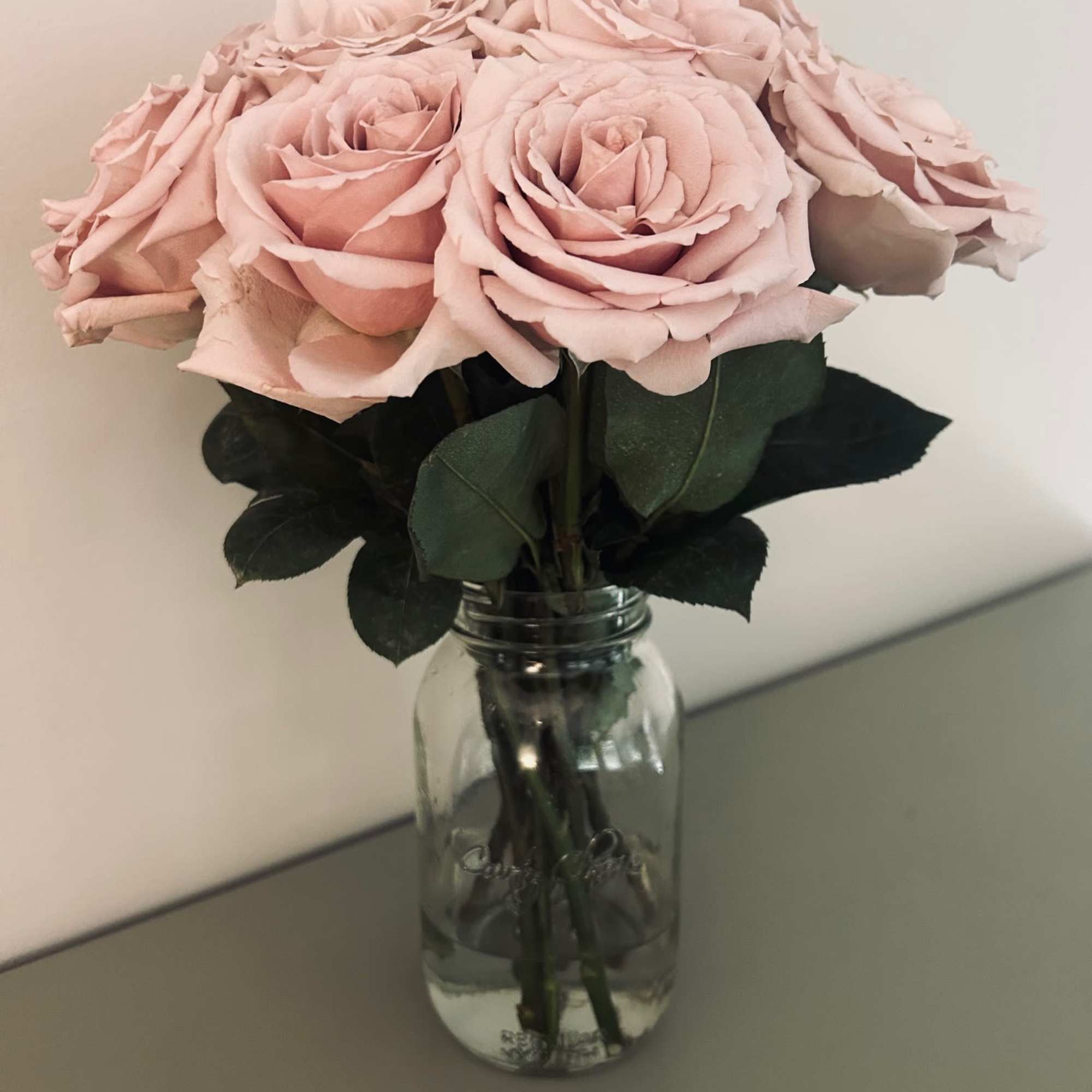 12 fresh cut roses of your color choice arranged delicately in a