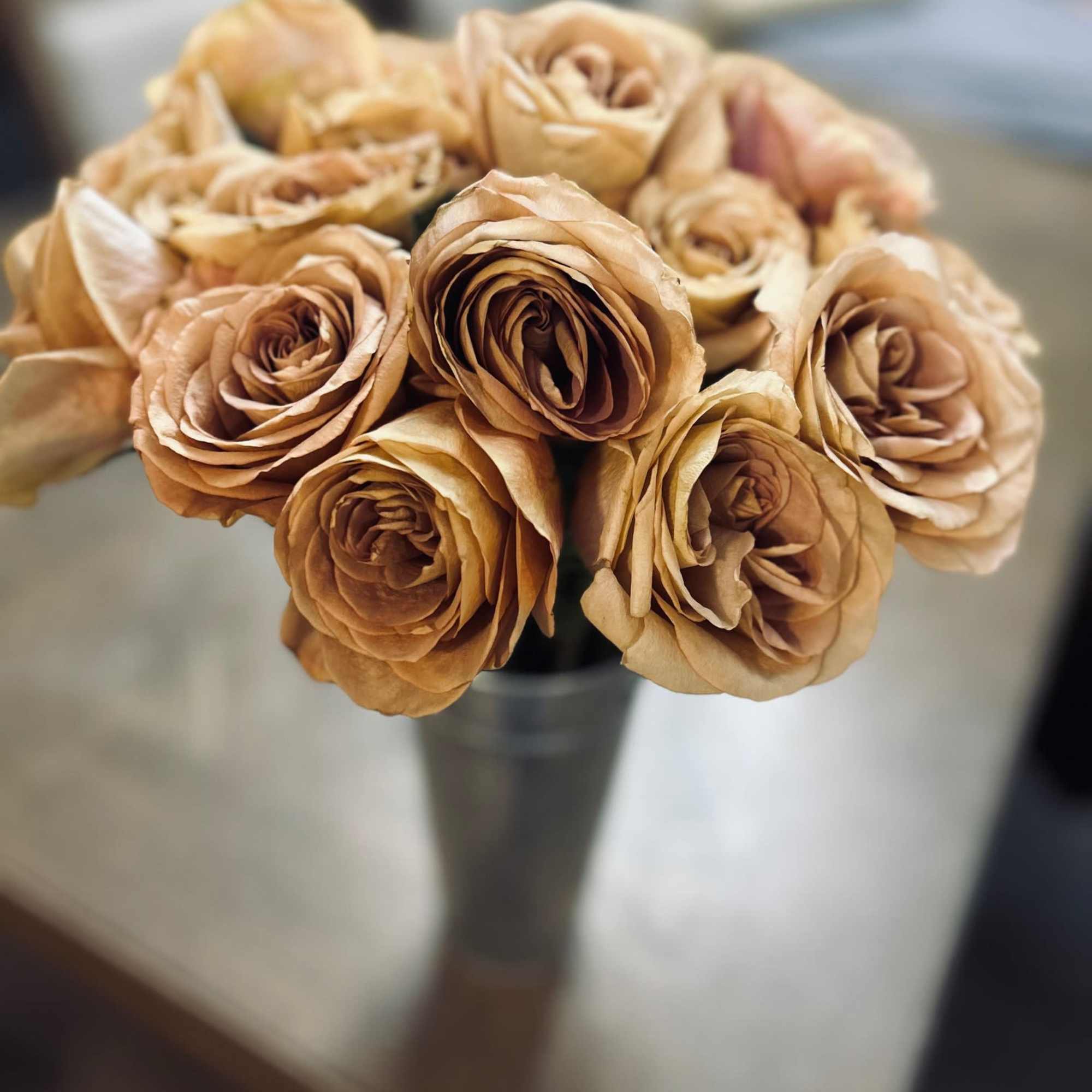 24 roses of your color choice delicately arranged in a sturdy, metal