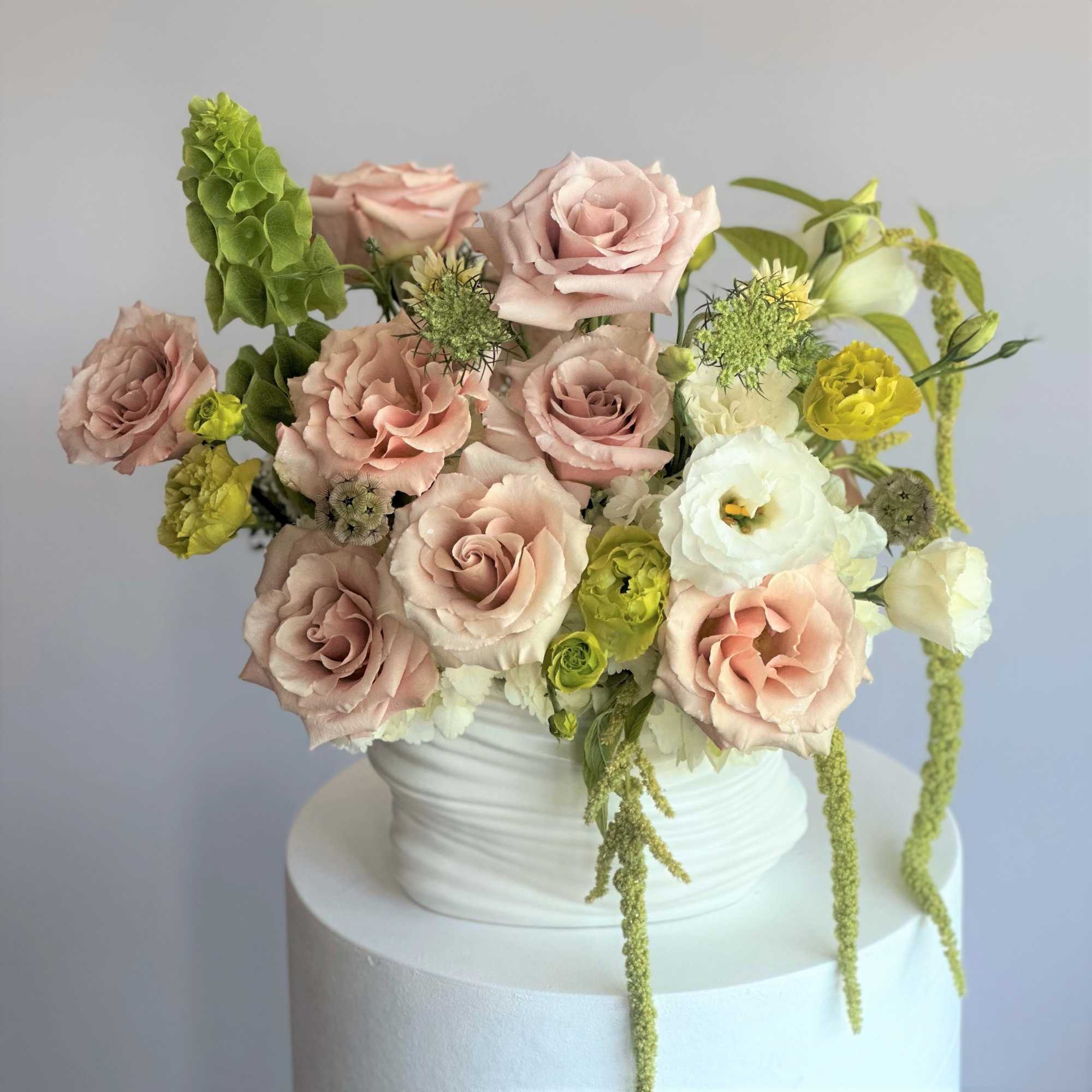 This soft and elegant arrangement features blush pink roses, creamy white blooms