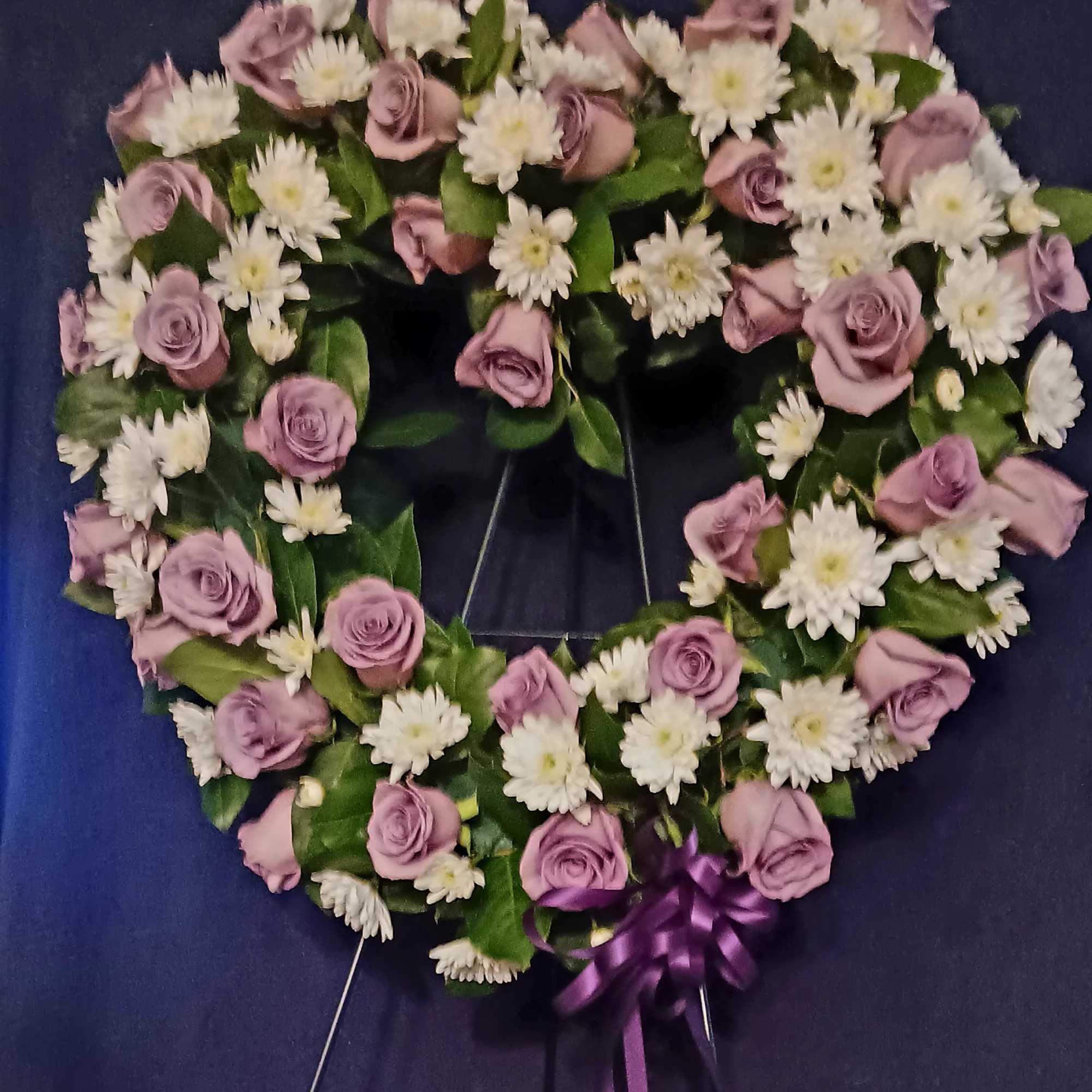 This lavender and white heart is full of beautiful lavender Roses accented