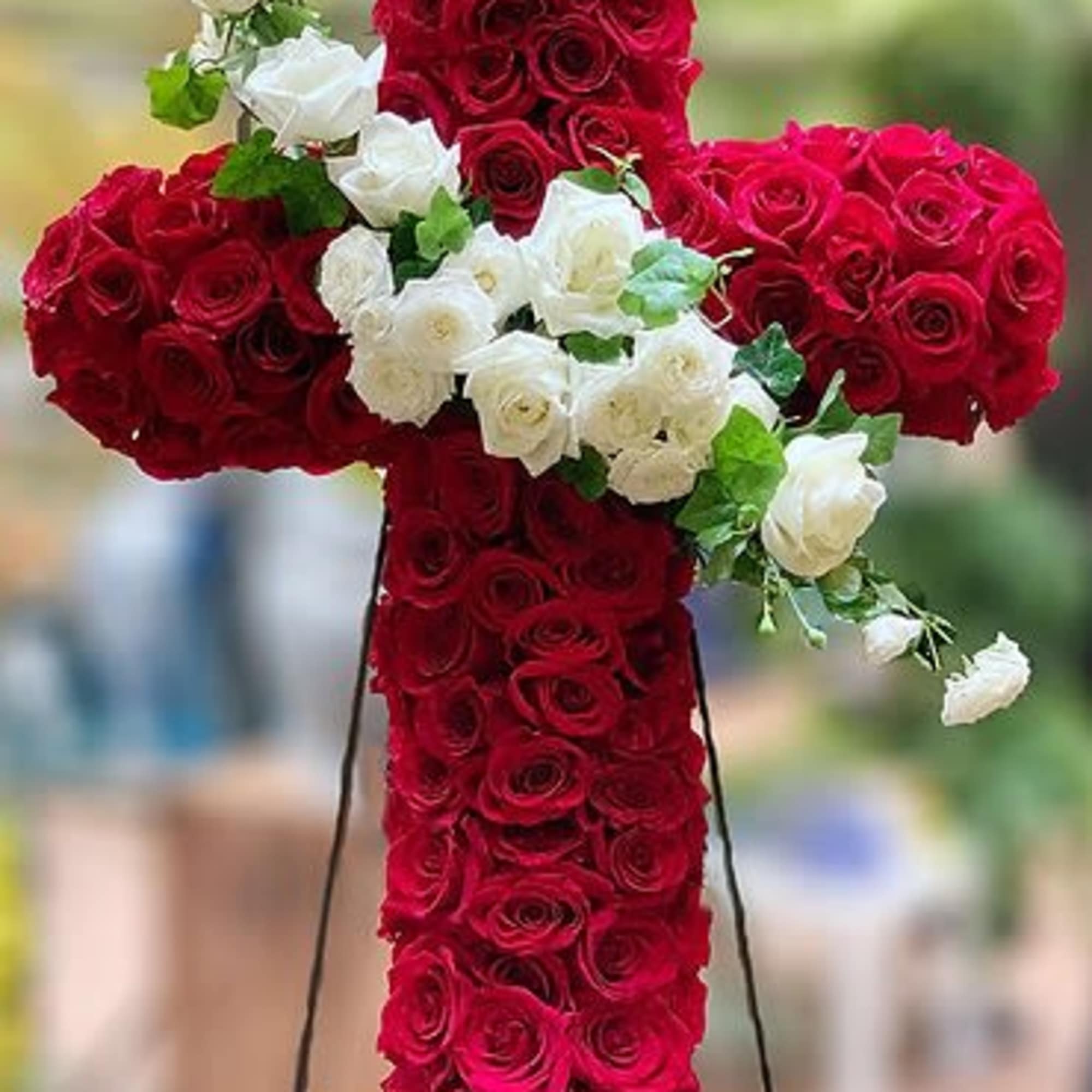 This large dramatic cross is a pave of dozens of roses and