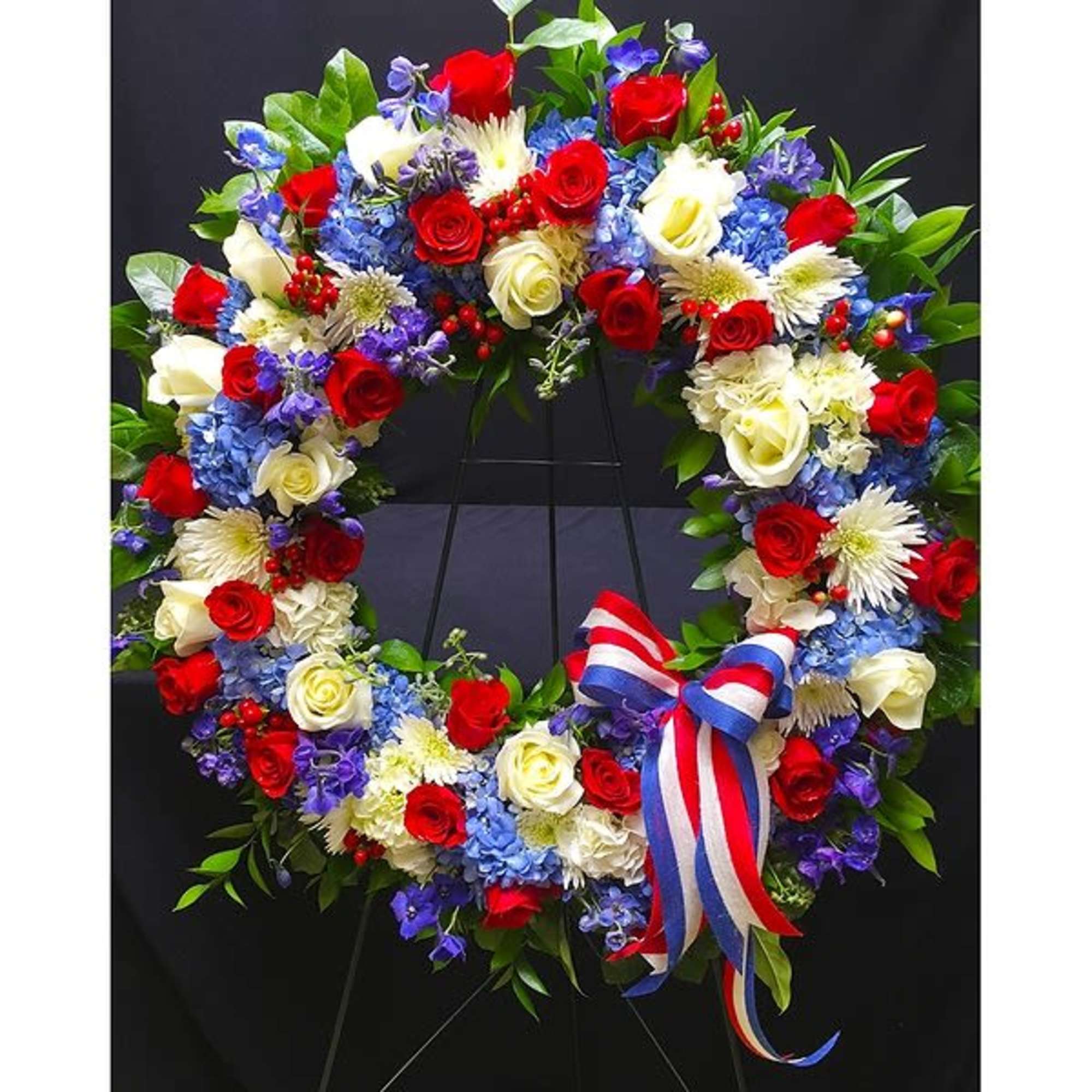This Patriotic Wreath is paved with seasonal flowers, hydrangea and roses in