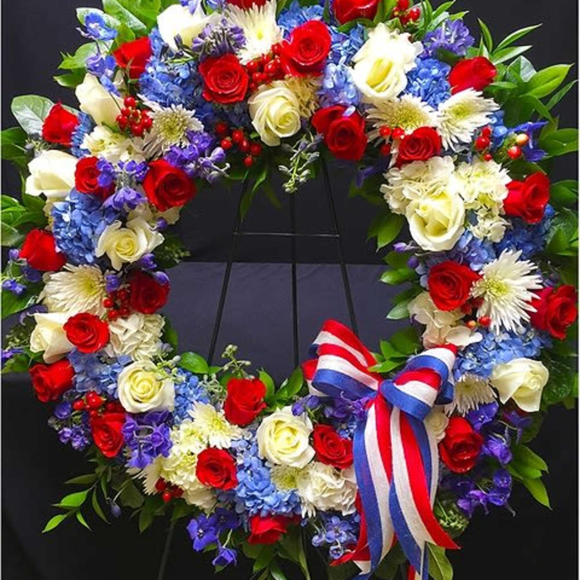 This Patriotic Wreath is paved with seasonal flowers, hydrangea and roses in
