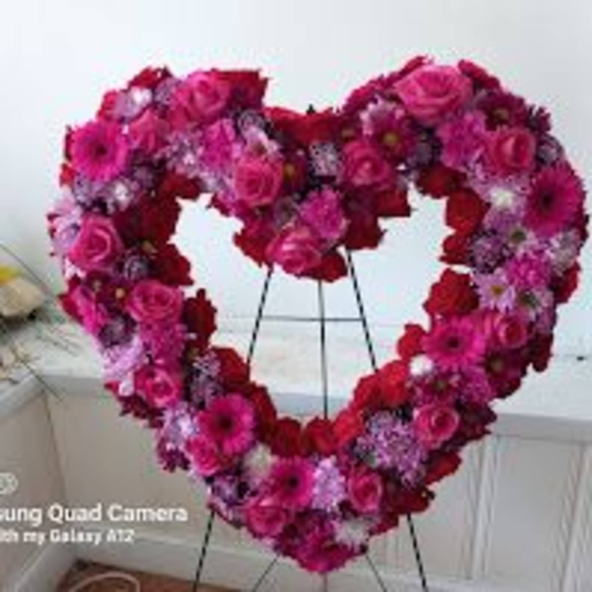Beautiful heart shaped wreath of fascia, burgundy and purple roses, carnations and