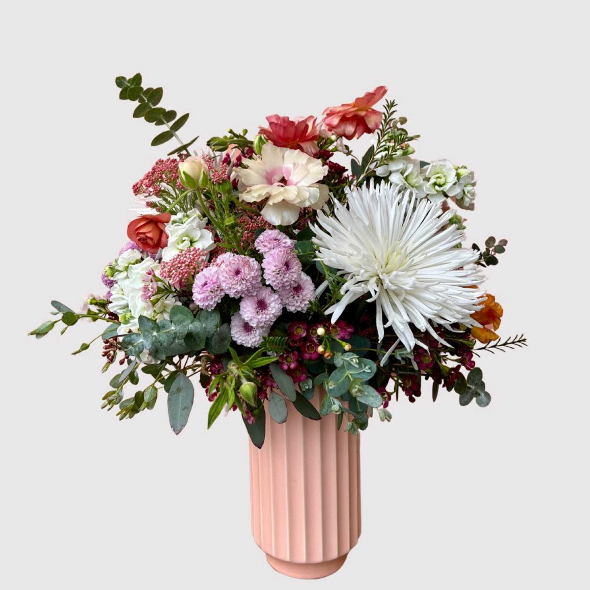 A blossoming arrangement artfully placed in a tall fluted vase that makes