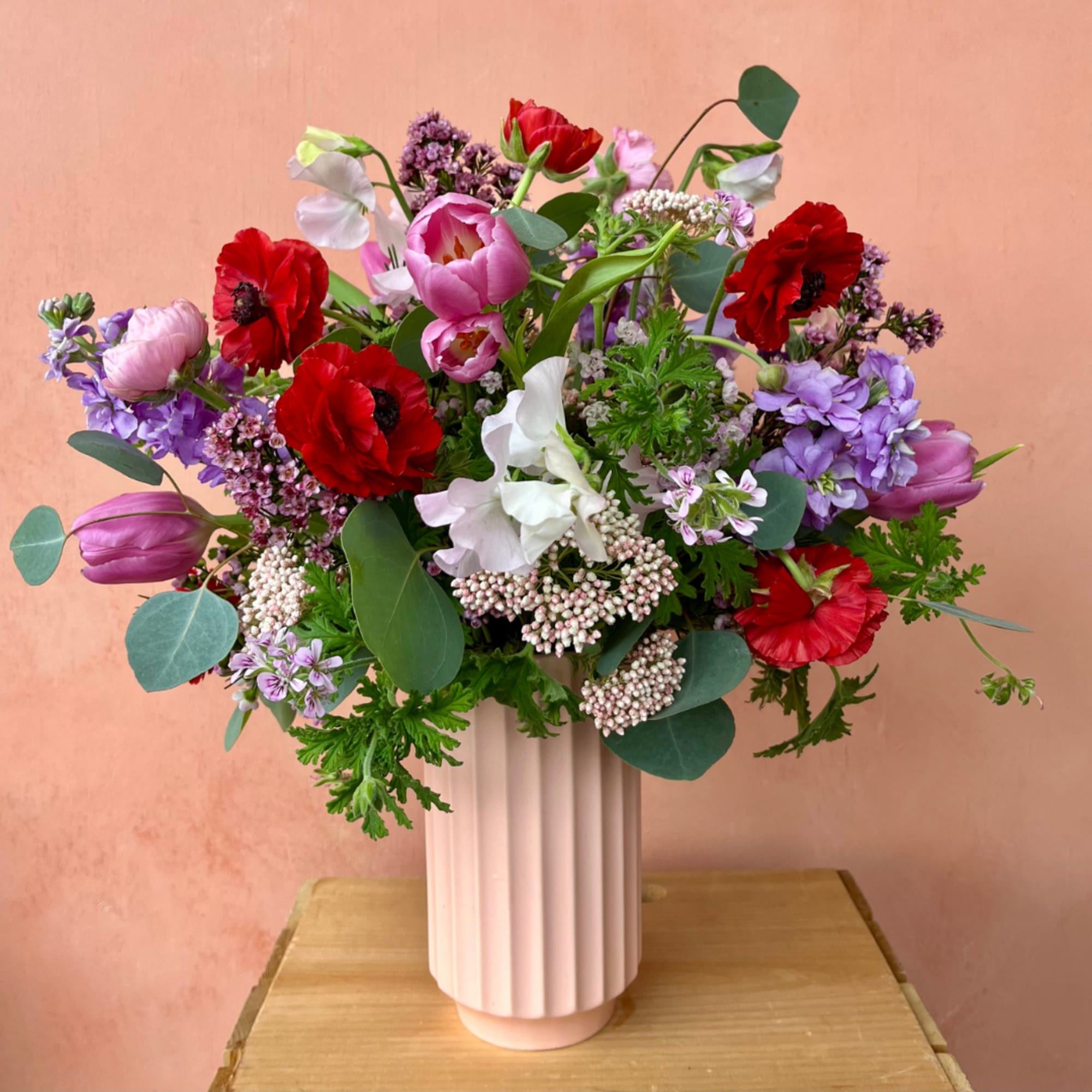 A blossoming arrangement artfully placed in a tall fluted vase that makes