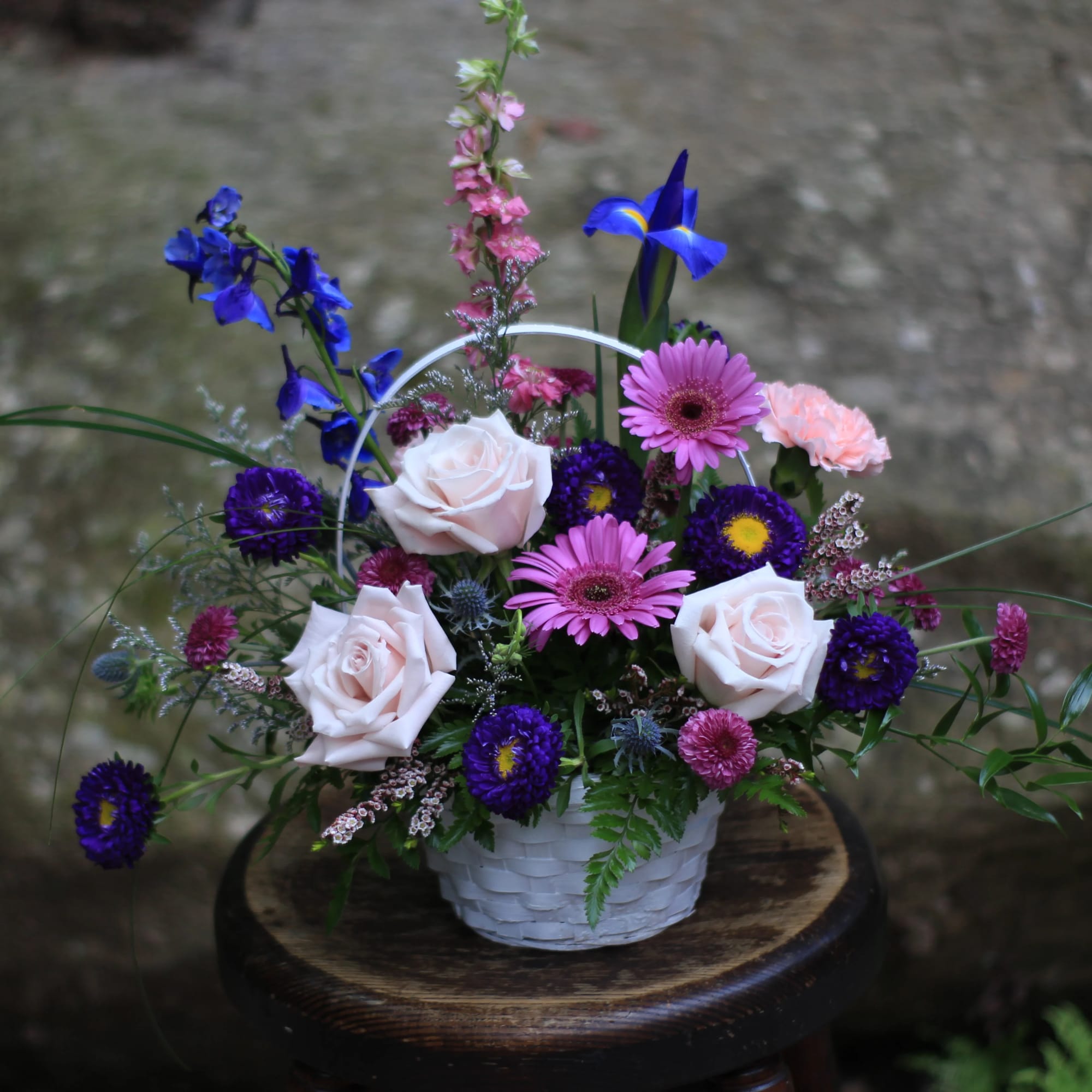 Country garden flowers arranged in a lovely basket. Pink, purple and blue Country garden flowers arranged in a lovely basket. Pink, purple and blue