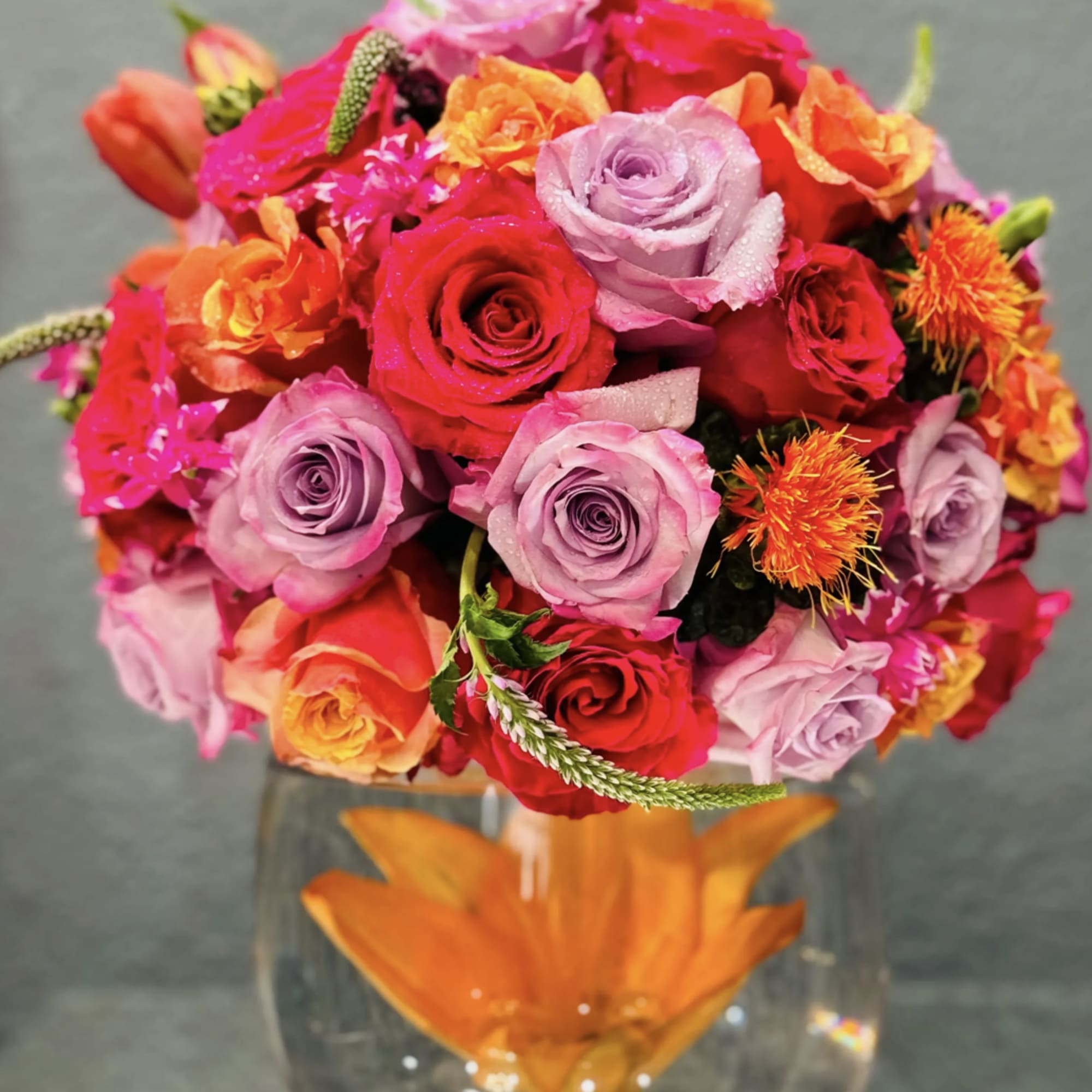 Glass bowl with submerged flowers and a full twist of summer bright