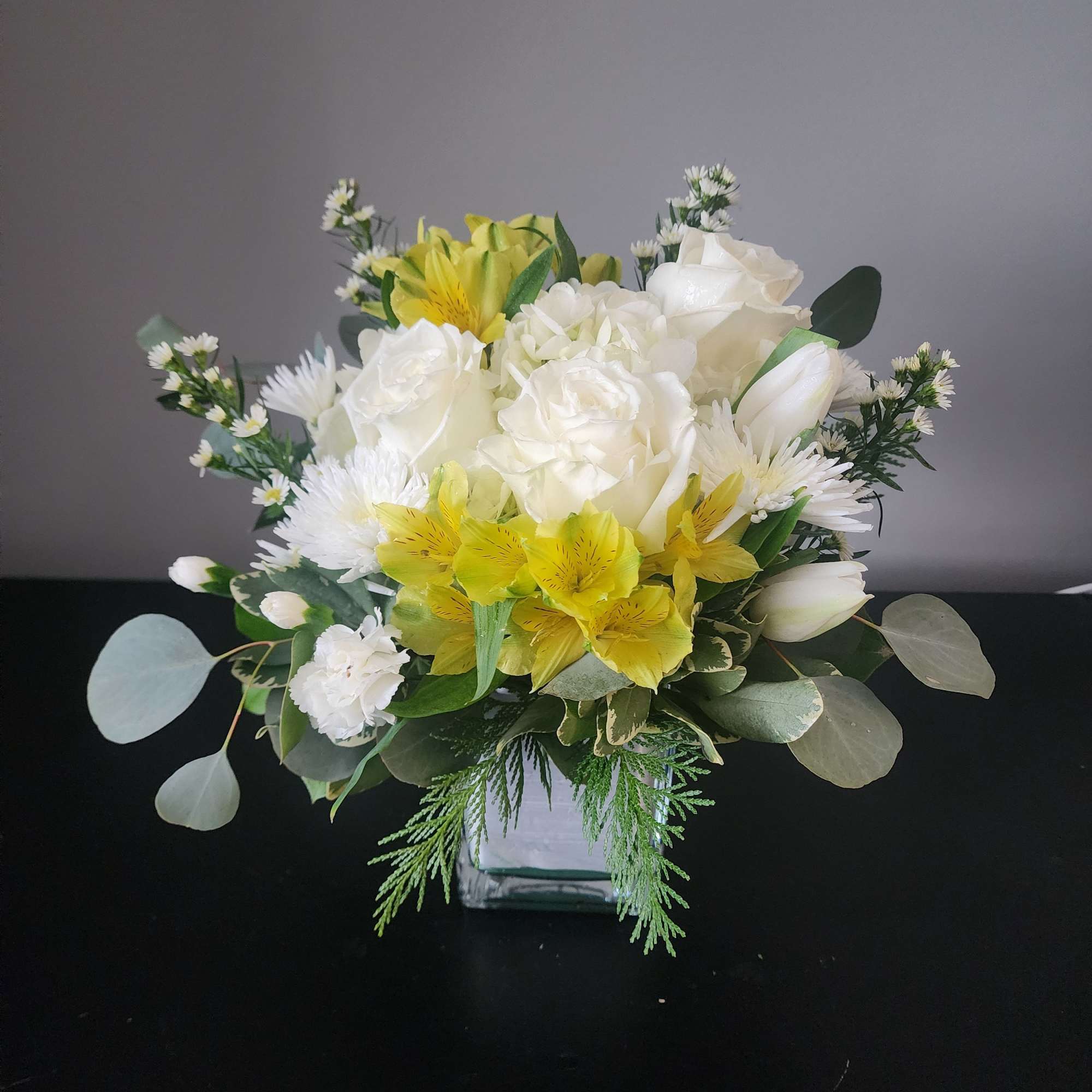 Designed in a glass cube with roses, alstroemeria, hydrangea, tulips, accent blooms