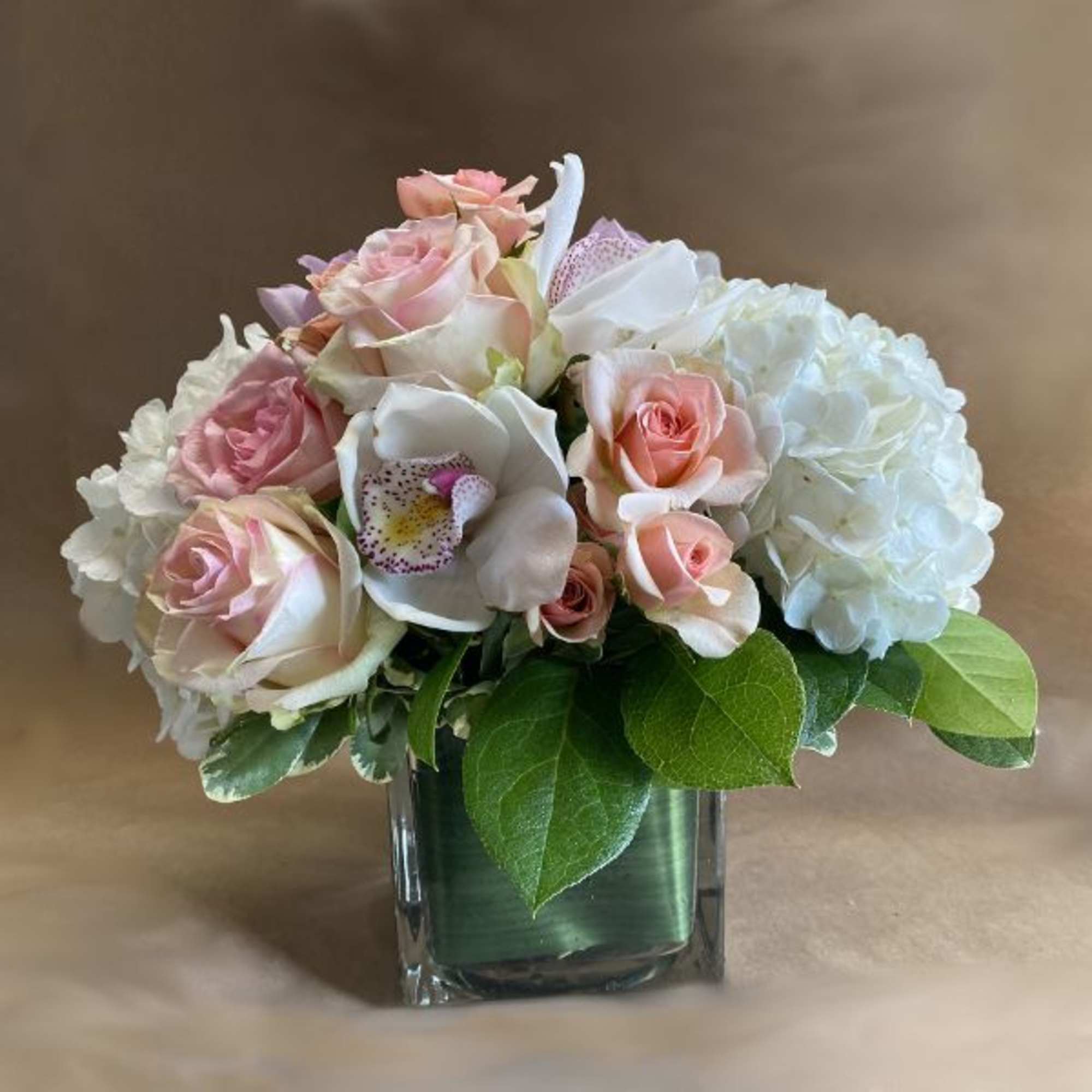 A luscious and elegant arrangement of flowers in pastel shades of peach
