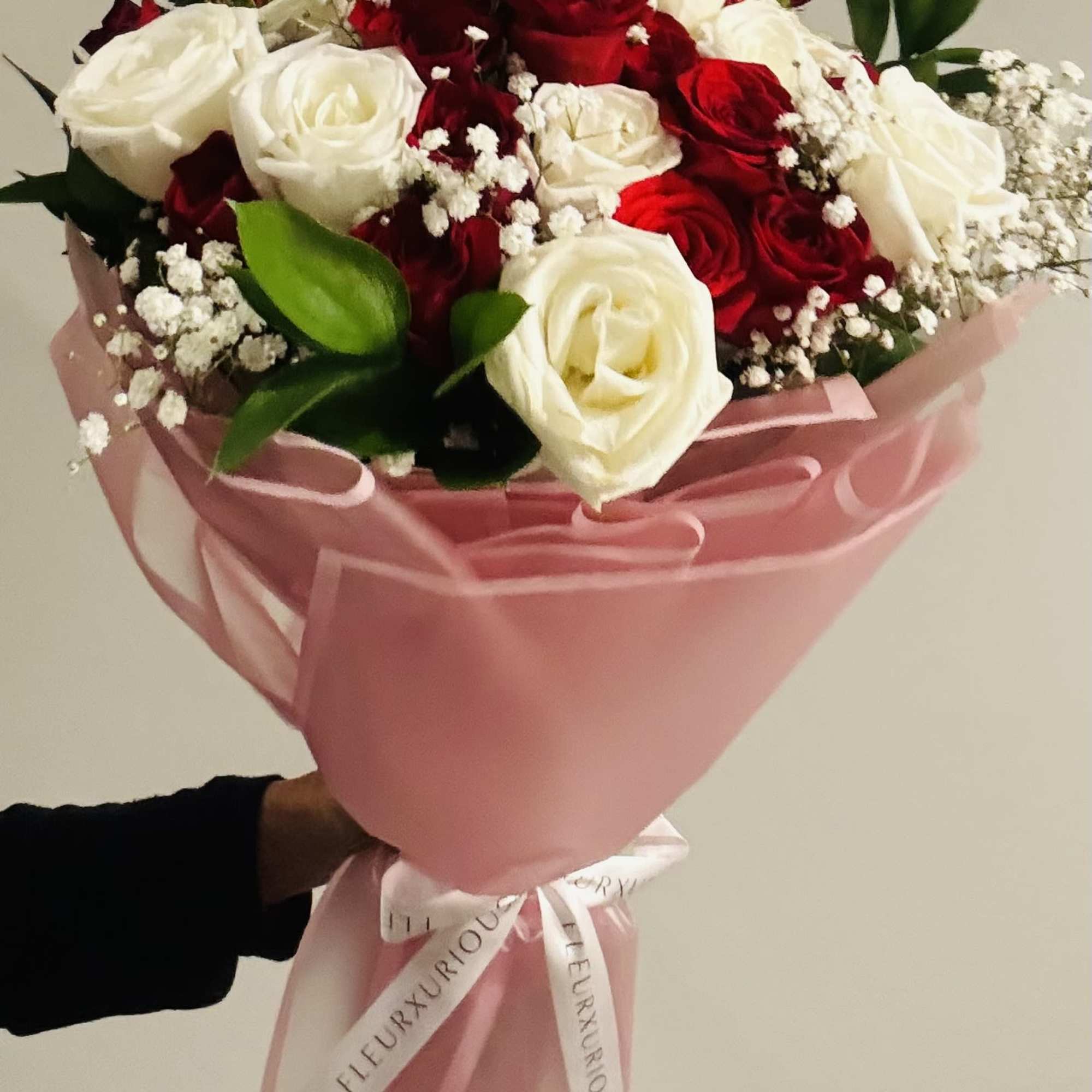 A mix of red &amp; white roses, babys breath, greenery hand tied