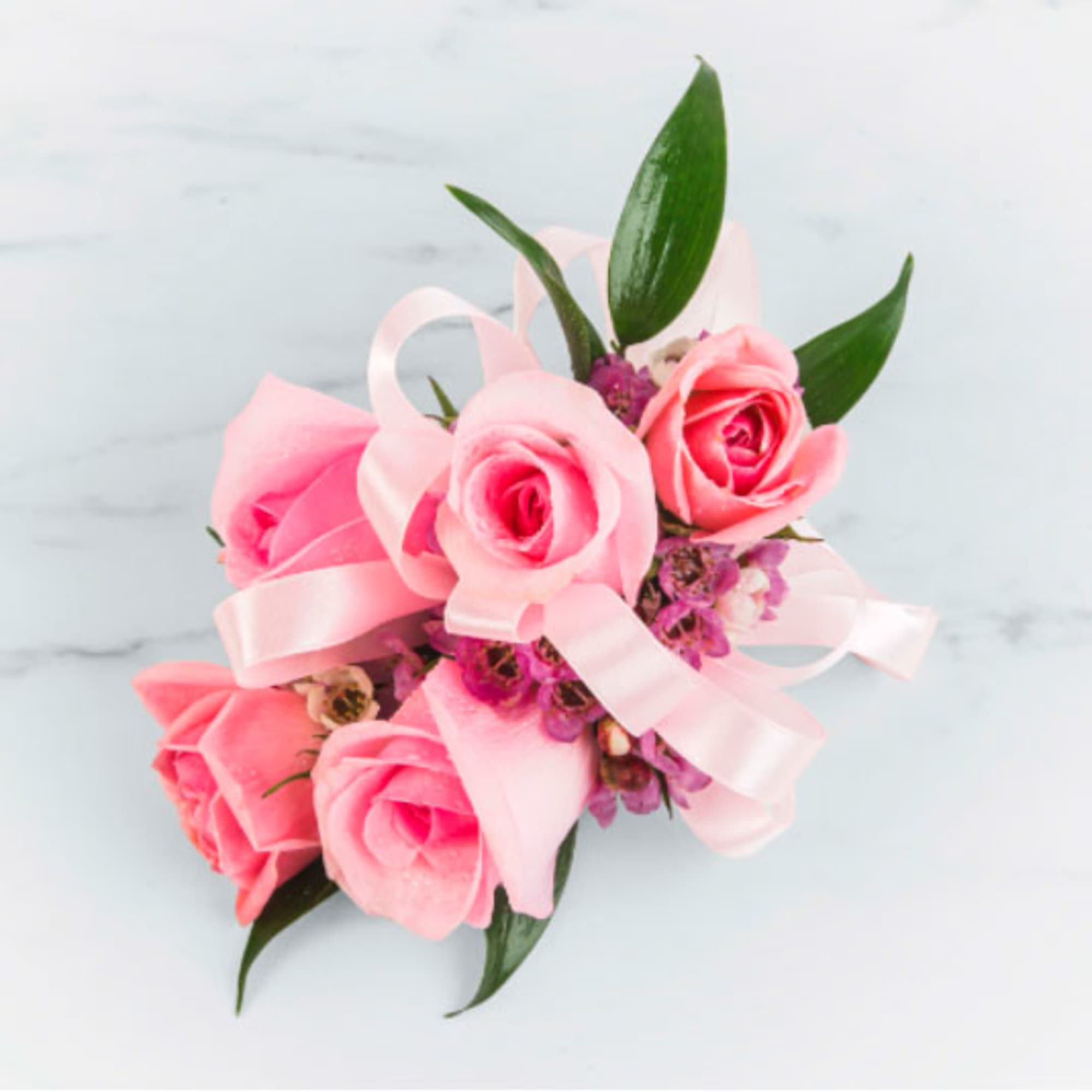 A classic miniature rose wrist corsage with sheer ribbon. A perfect complement