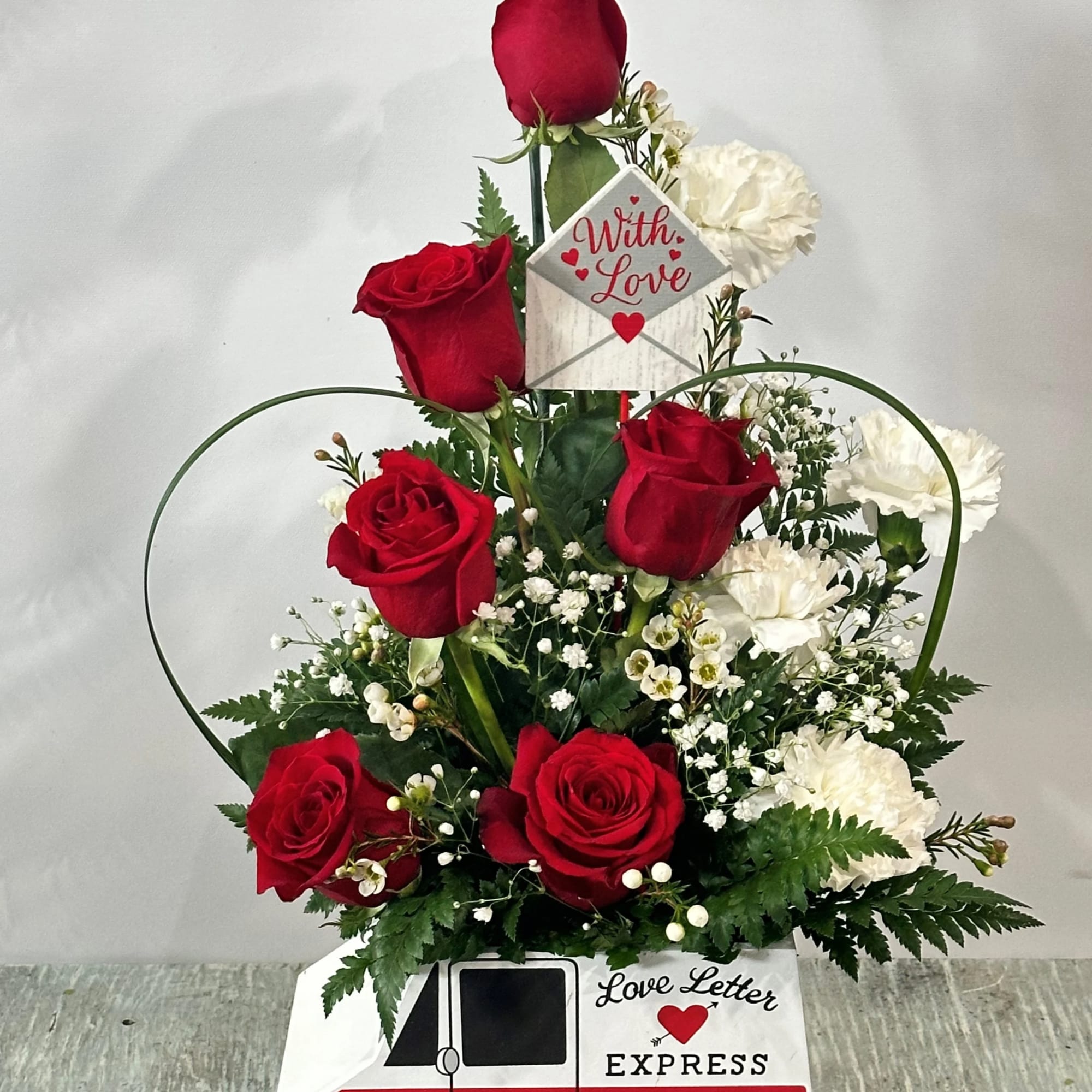 Arrangement of red roses and white carnations designed in a wooden container Arrangement of red roses and white carnations designed in a wooden container