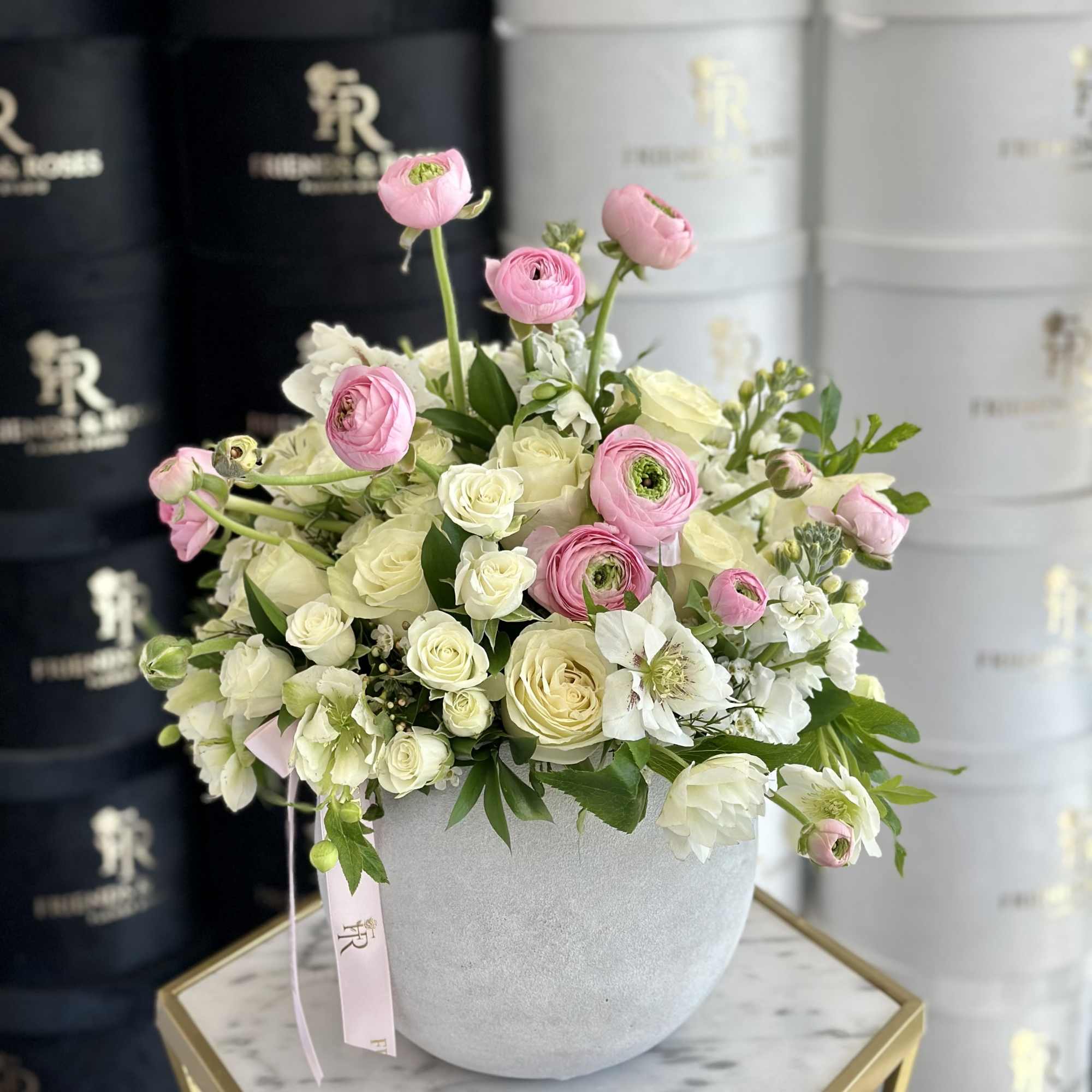 A delicate, sophisticated composition of roses and ranunculus, their velvety petals in