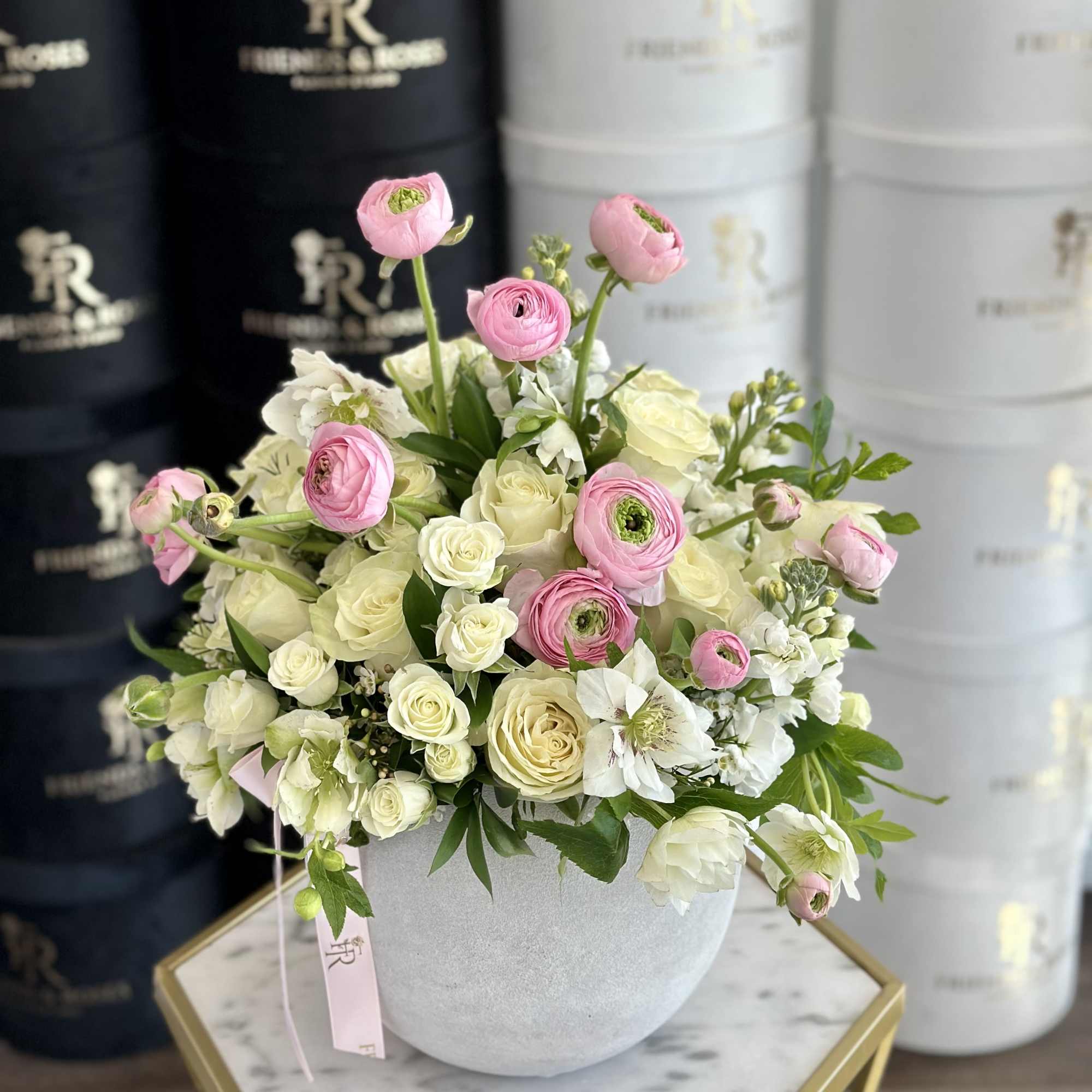 A delicate, sophisticated composition of roses and ranunculus, their velvety petals in