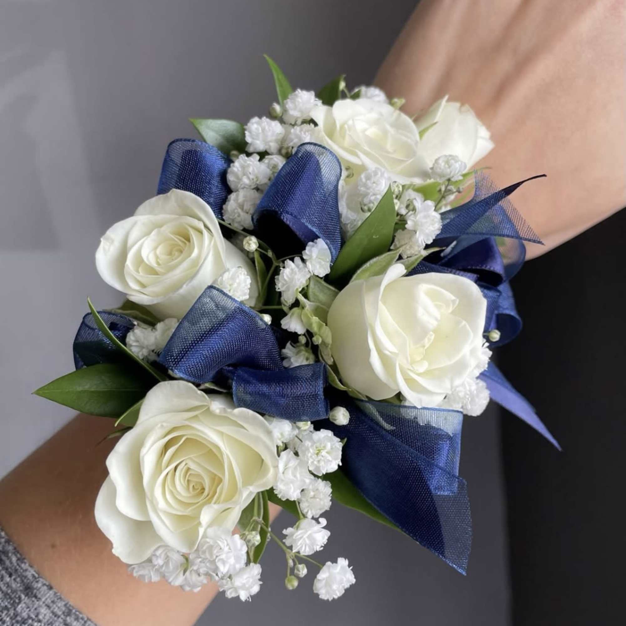 1 corsage, with white roses (or another color) baby breath, green leaves