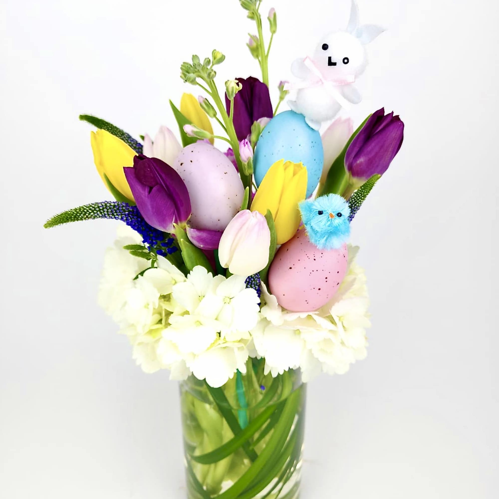 Floral arrangements of colorful Tulips, Veronicas, Stock, white hydrangeas, greens, colorful eggs