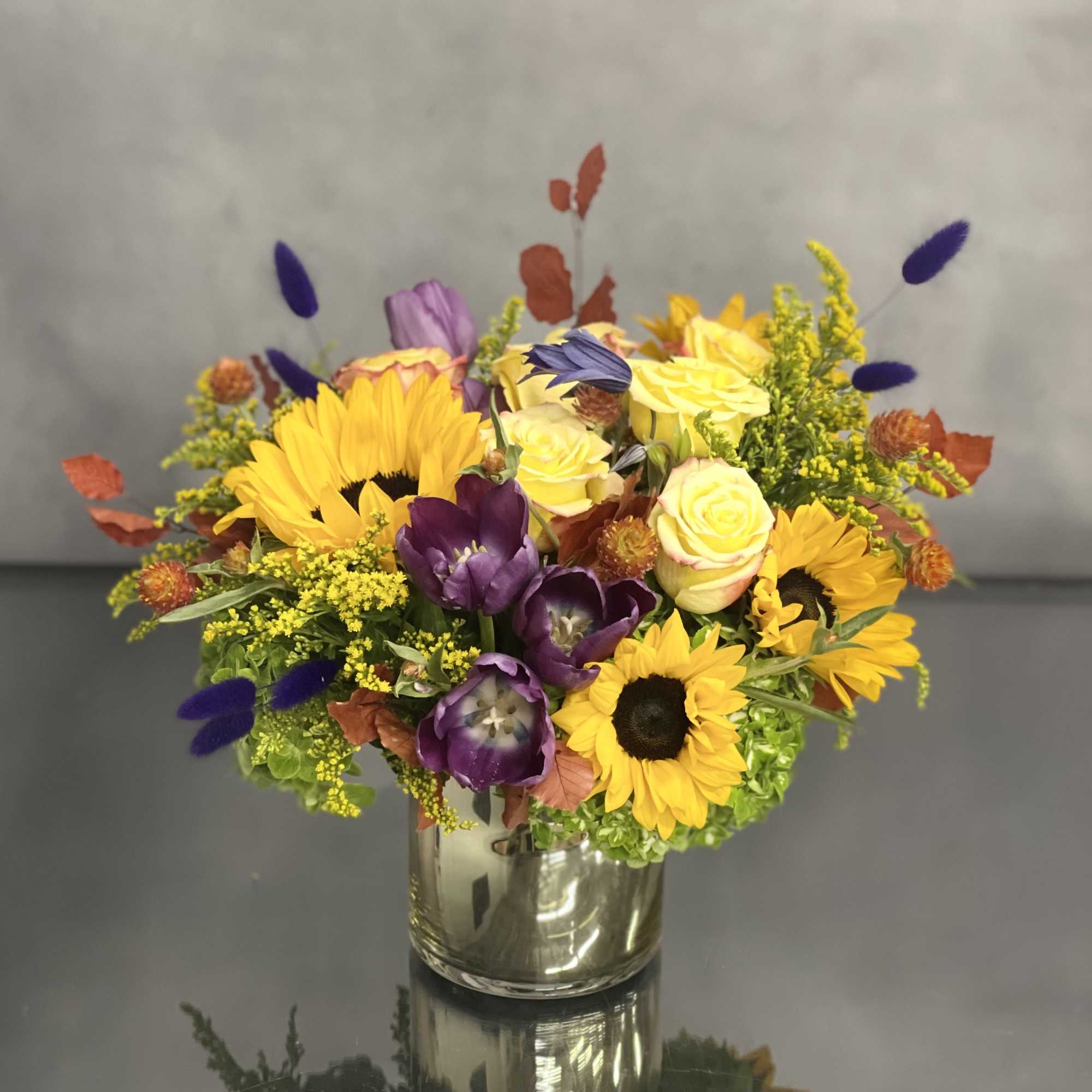 Deliver happiness with this abundant fall floral including sunflower, tulips, roses and Deliver happiness with this abundant fall floral including sunflower, tulips, roses and