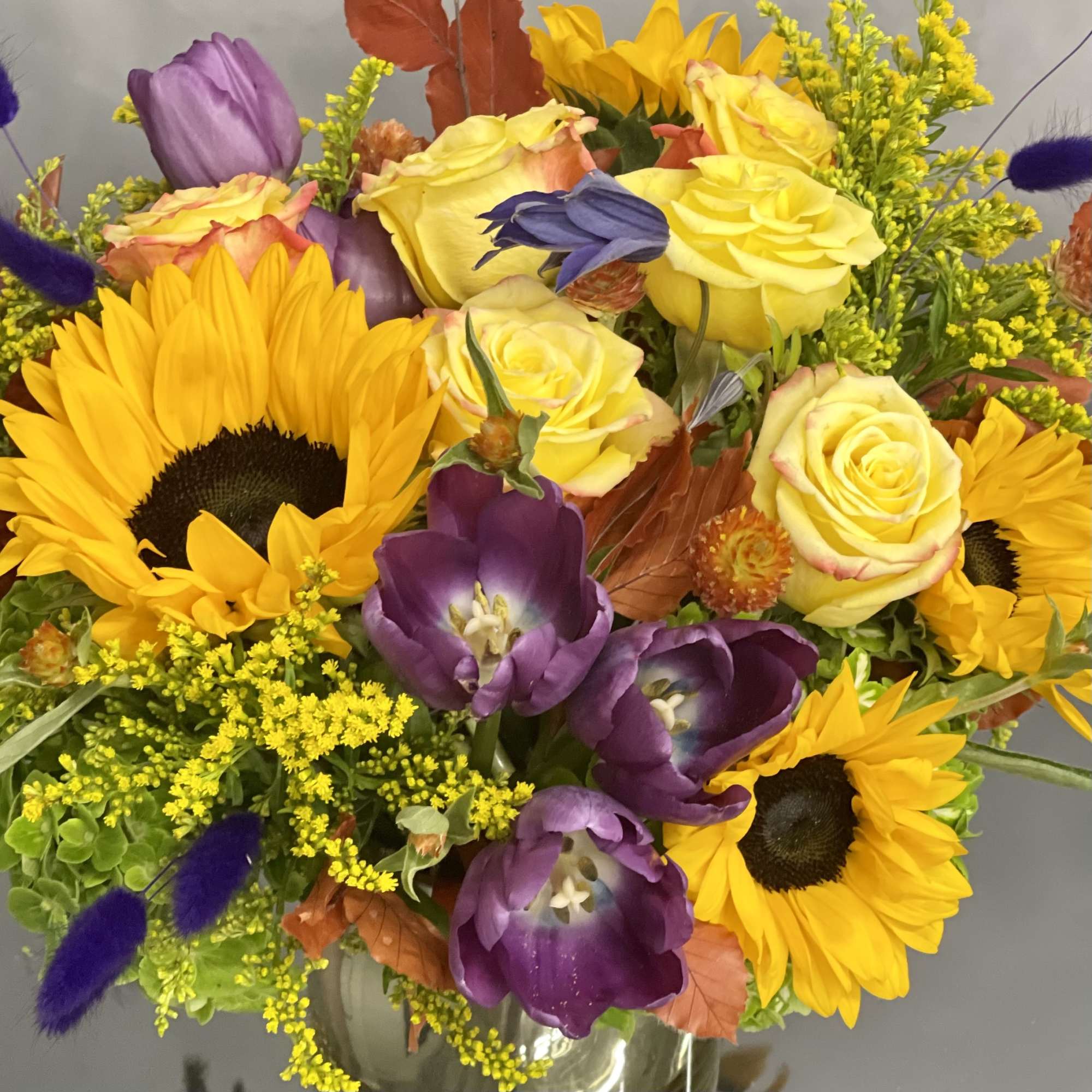 Deliver happiness with this abundant fall floral including sunflower, tulips, roses and Deliver happiness with this abundant fall floral including sunflower, tulips, roses and