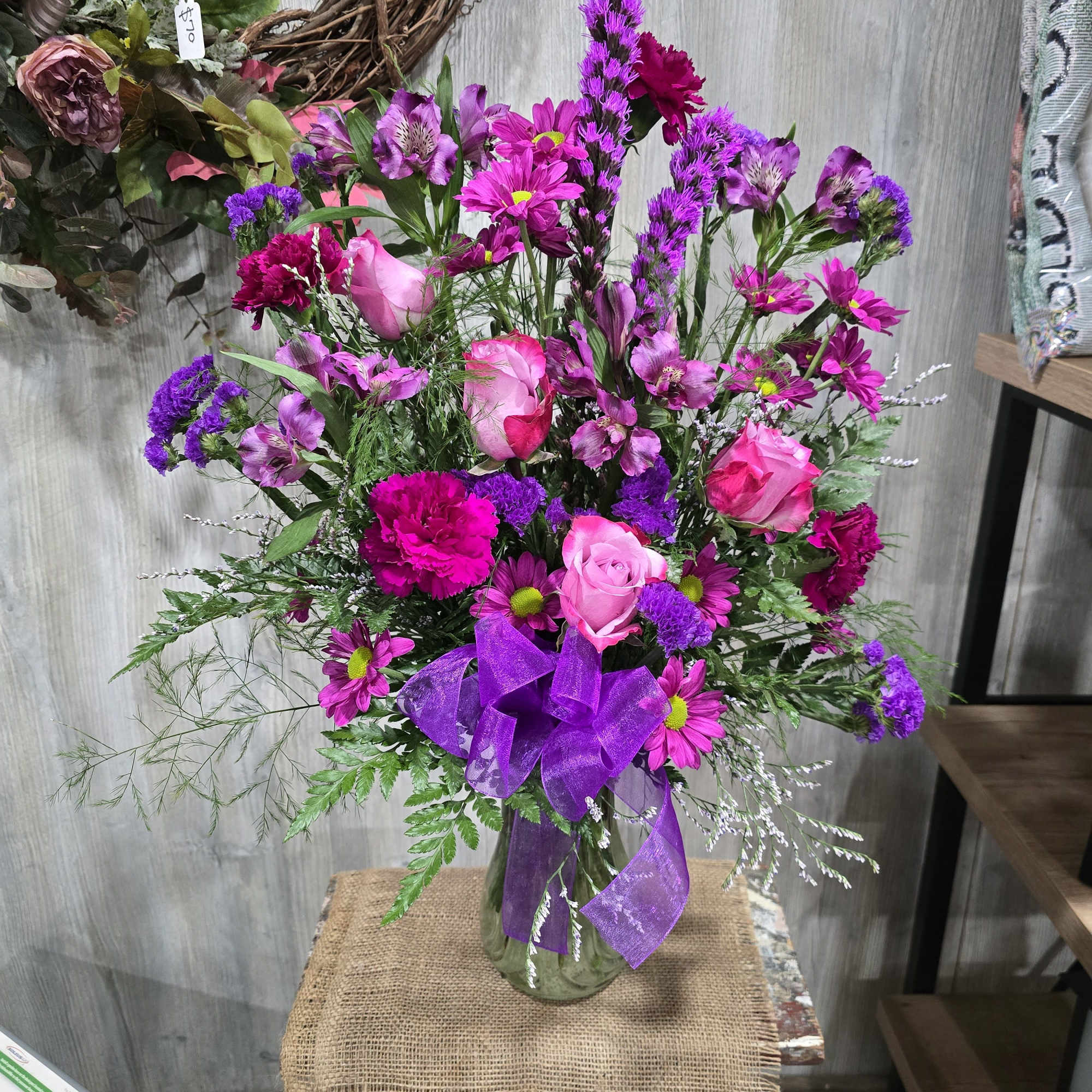 Beautifully designed with deep purple roses, carnations, liatris, and lavender daisies! 