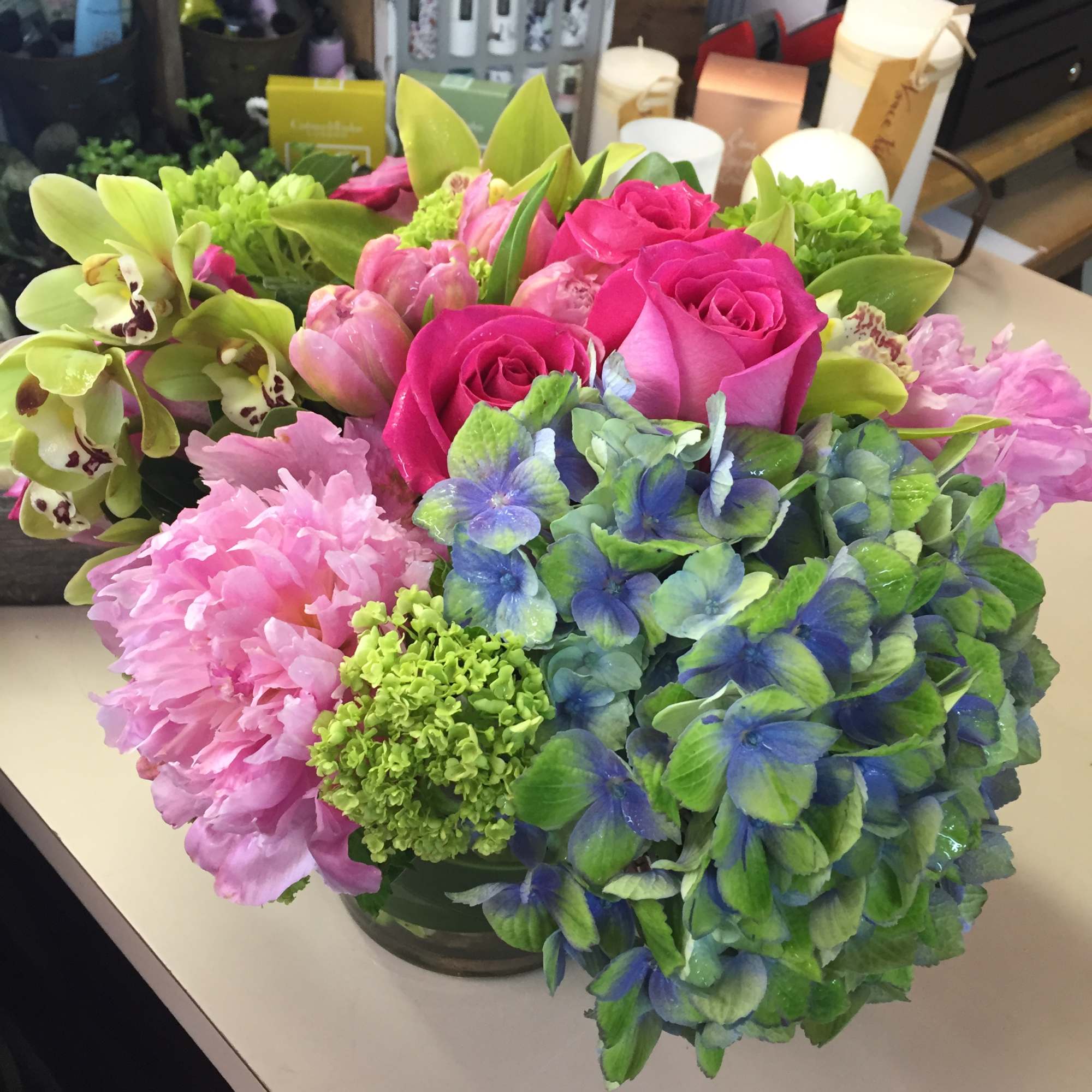 Cymbidium orchids, tulips. hot pink roses compliment funky hydrangea. Colors may vary Cymbidium orchids, tulips. hot pink roses compliment funky hydrangea. Colors may vary