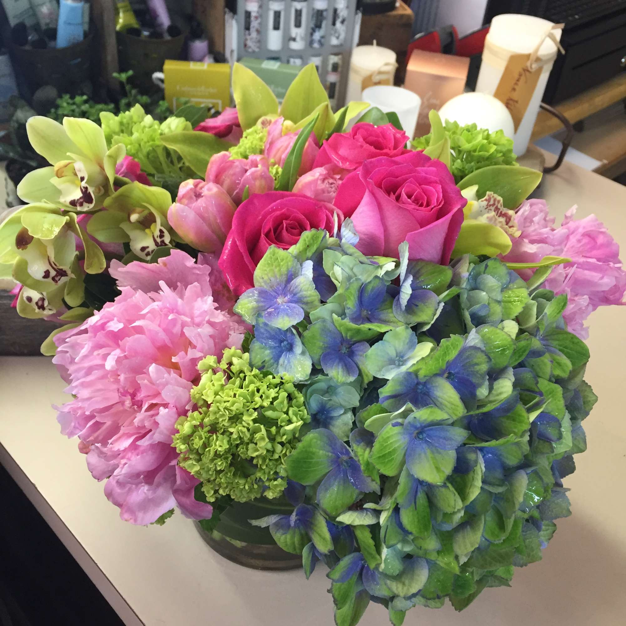 Cymbidium orchids, tulips. hot pink roses compliment funky hydrangea. Colors may vary Cymbidium orchids, tulips. hot pink roses compliment funky hydrangea. Colors may vary