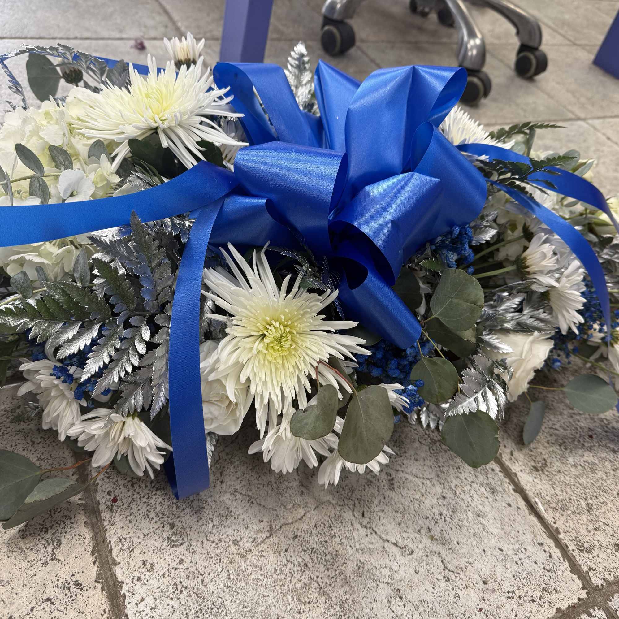 3 ft long dish centerpiece with white spider flowers, daisies, eucalyptus, and